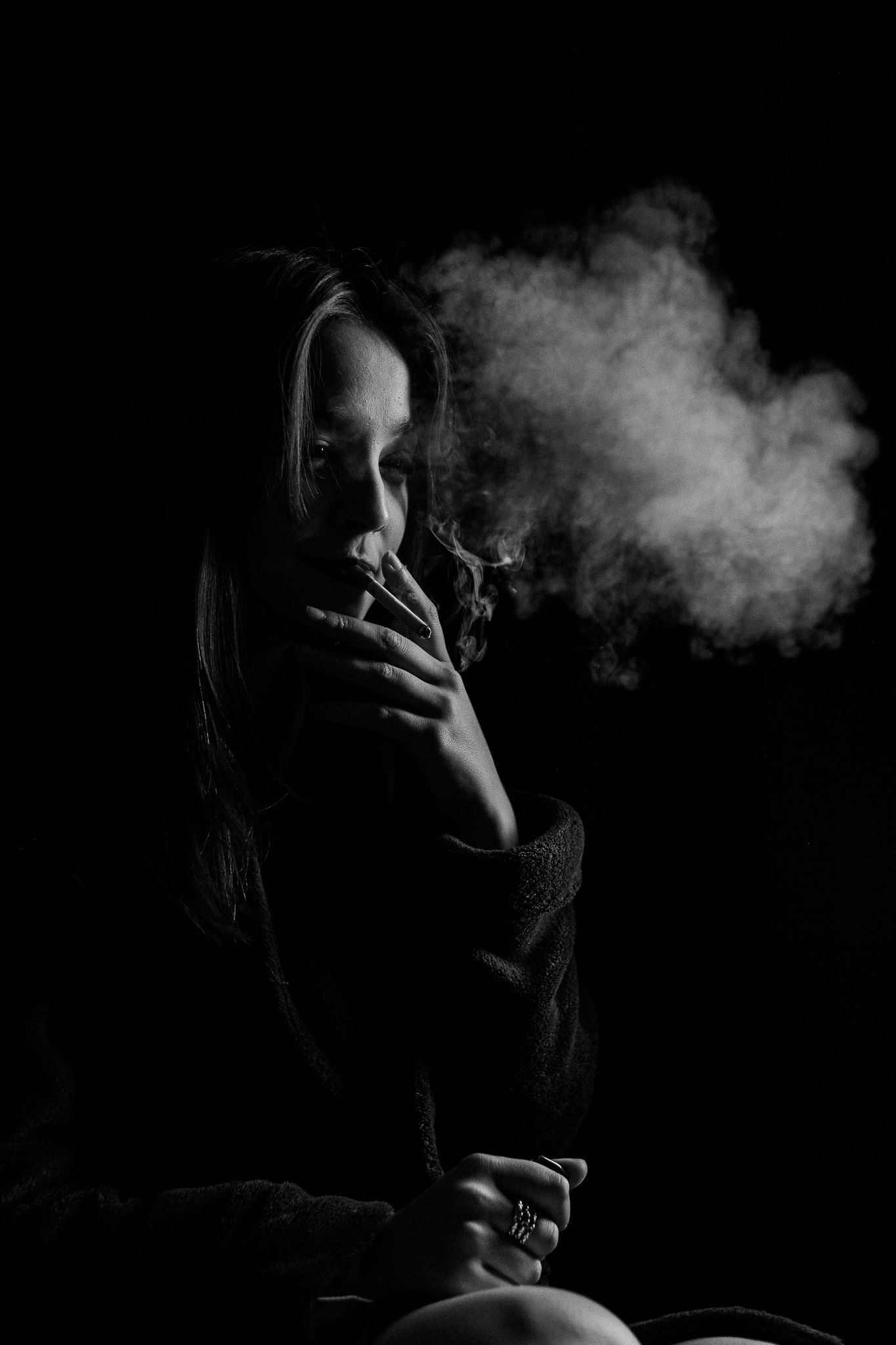 Dramatic low-key portrait series with smoke elements against a dark background.