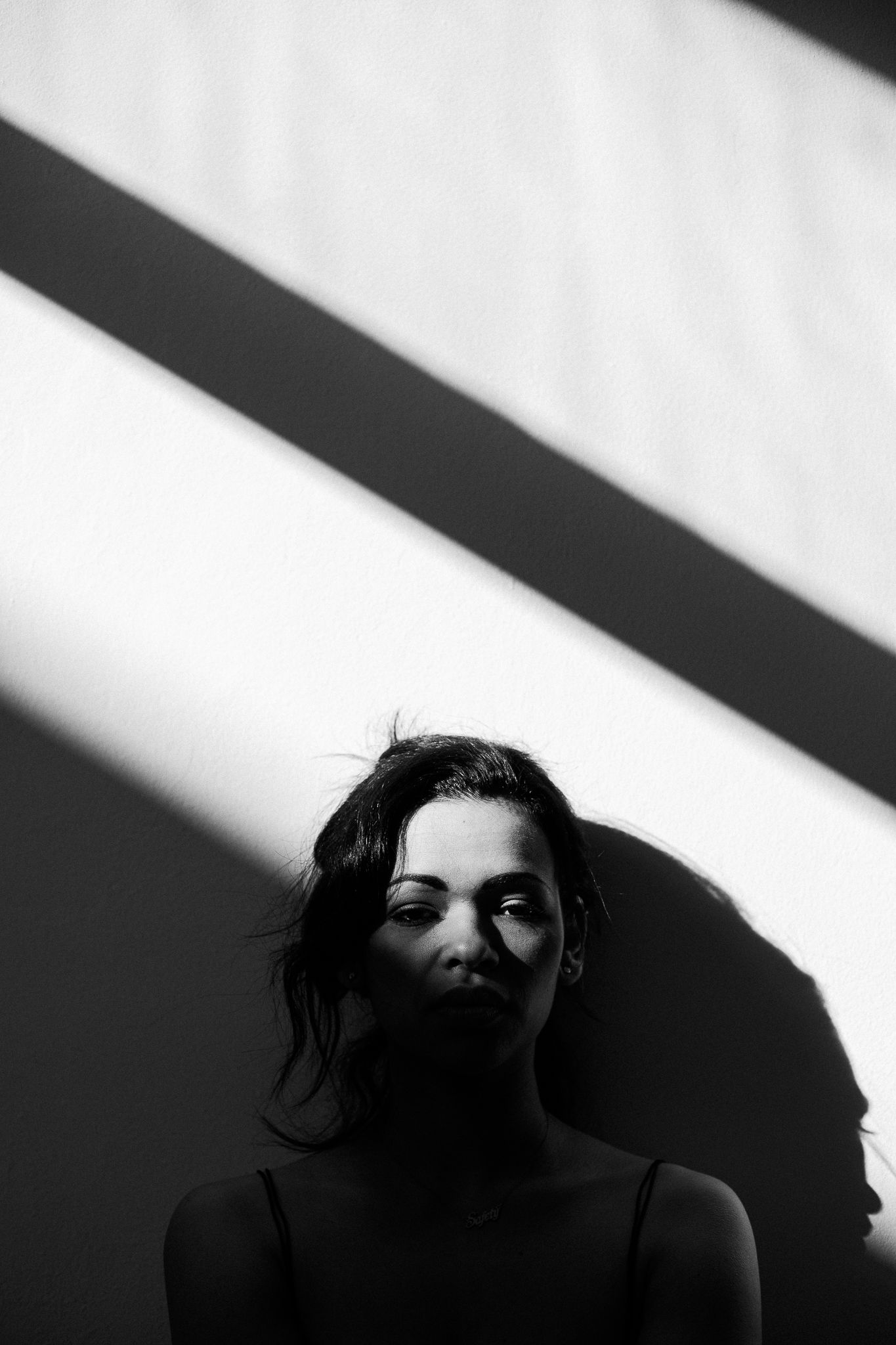 Dramatic high contrast portraits with stark shadows creating a film noir aesthetic.