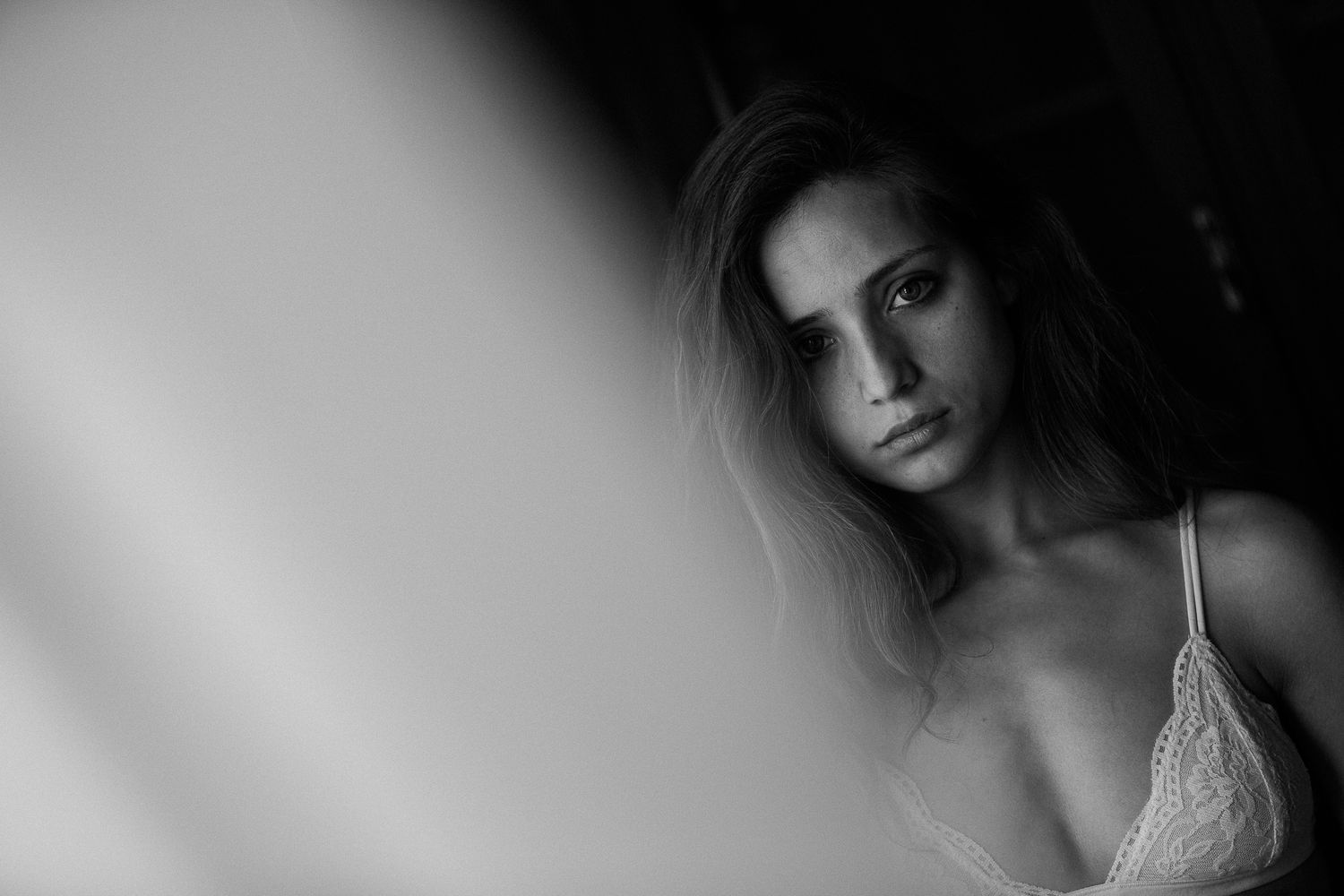 Black and white portrait series showing joyful expressions and laughter on bed.