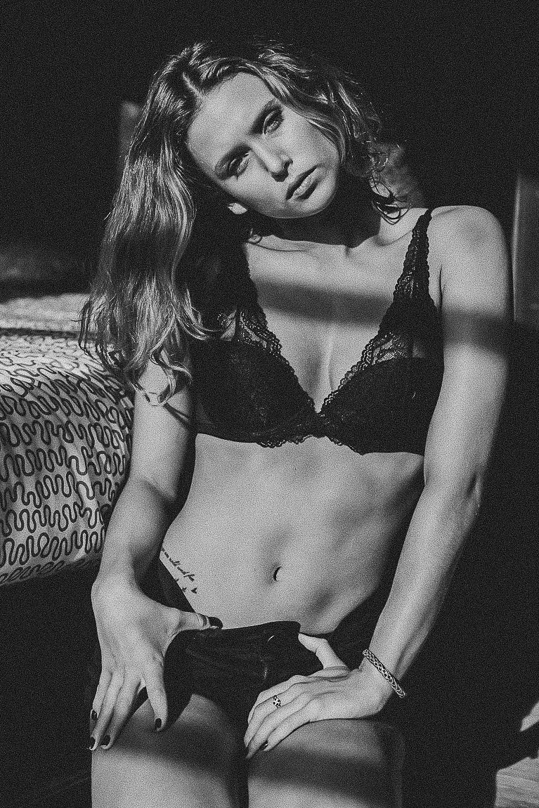 A black and white fashion photo series showing dramatic poses against textured upholstery in moody lighting.