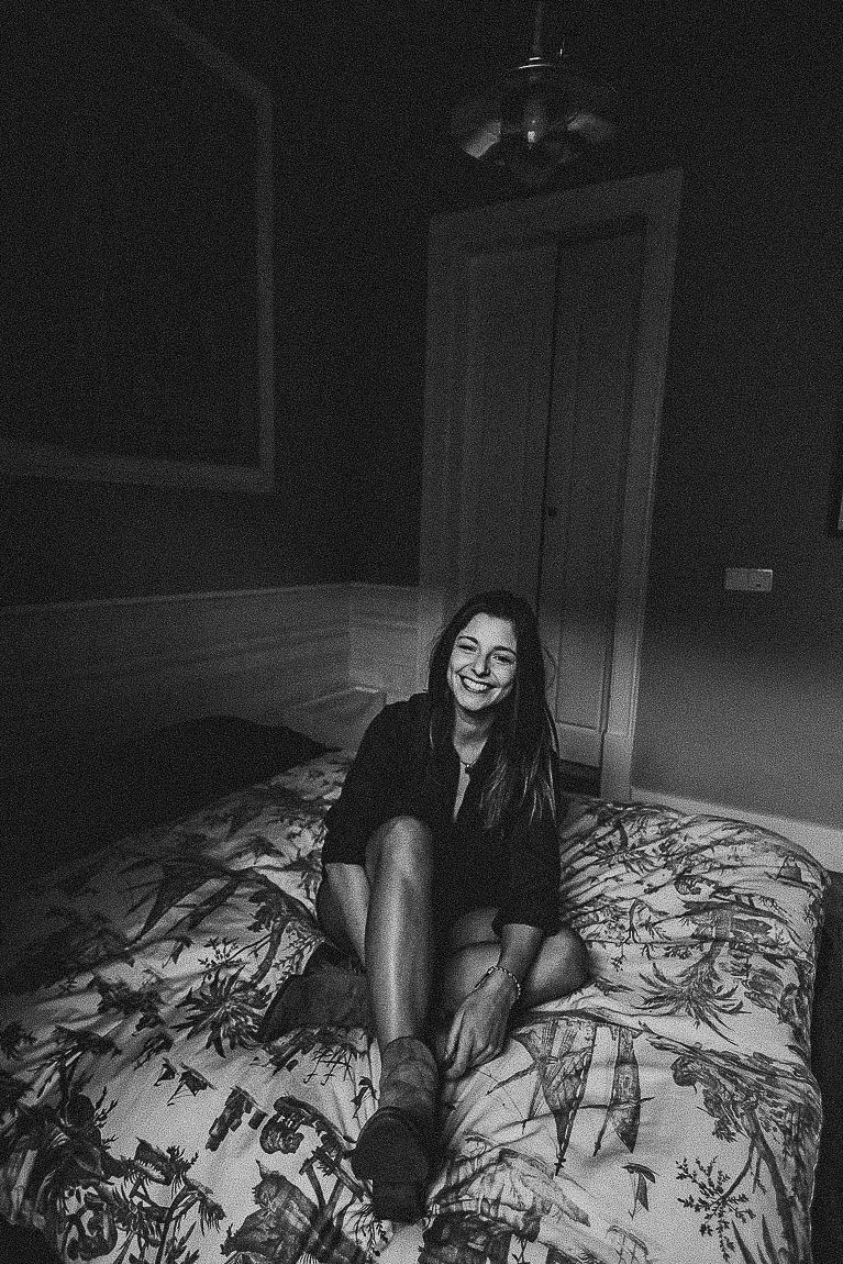 Person lounging on a floral print bed in black and white photography.