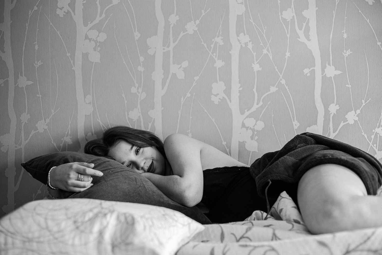 Intimate bedroom photo series with soft lighting and patterned wall details.