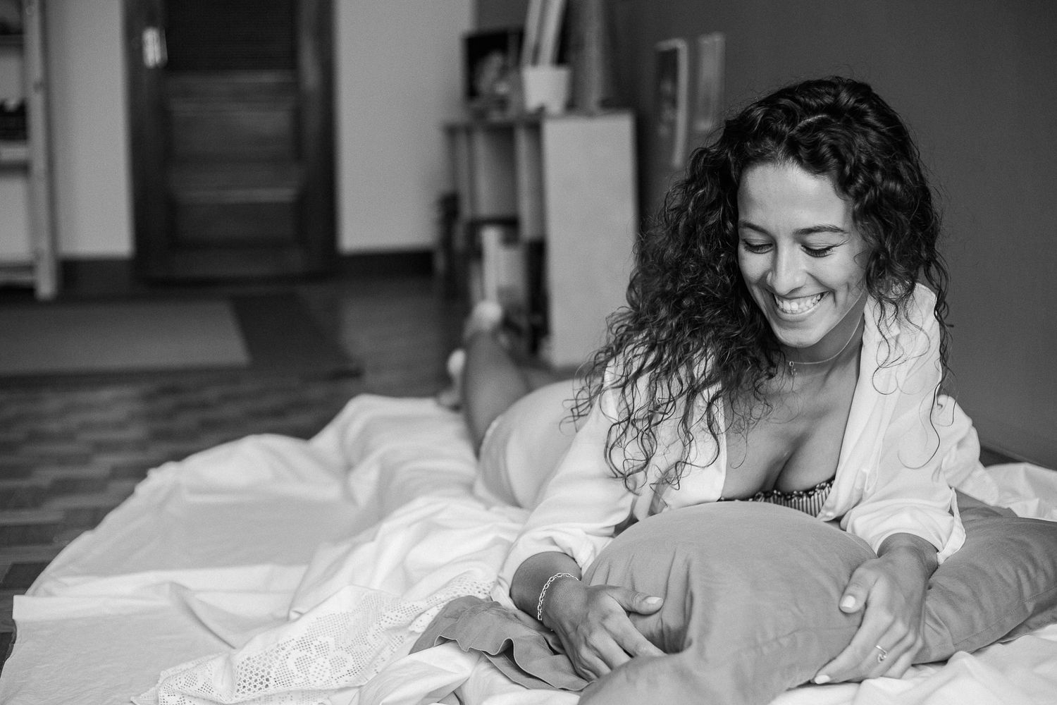 Black and white portrait series showing intimate moments between sheets in soft natural light.