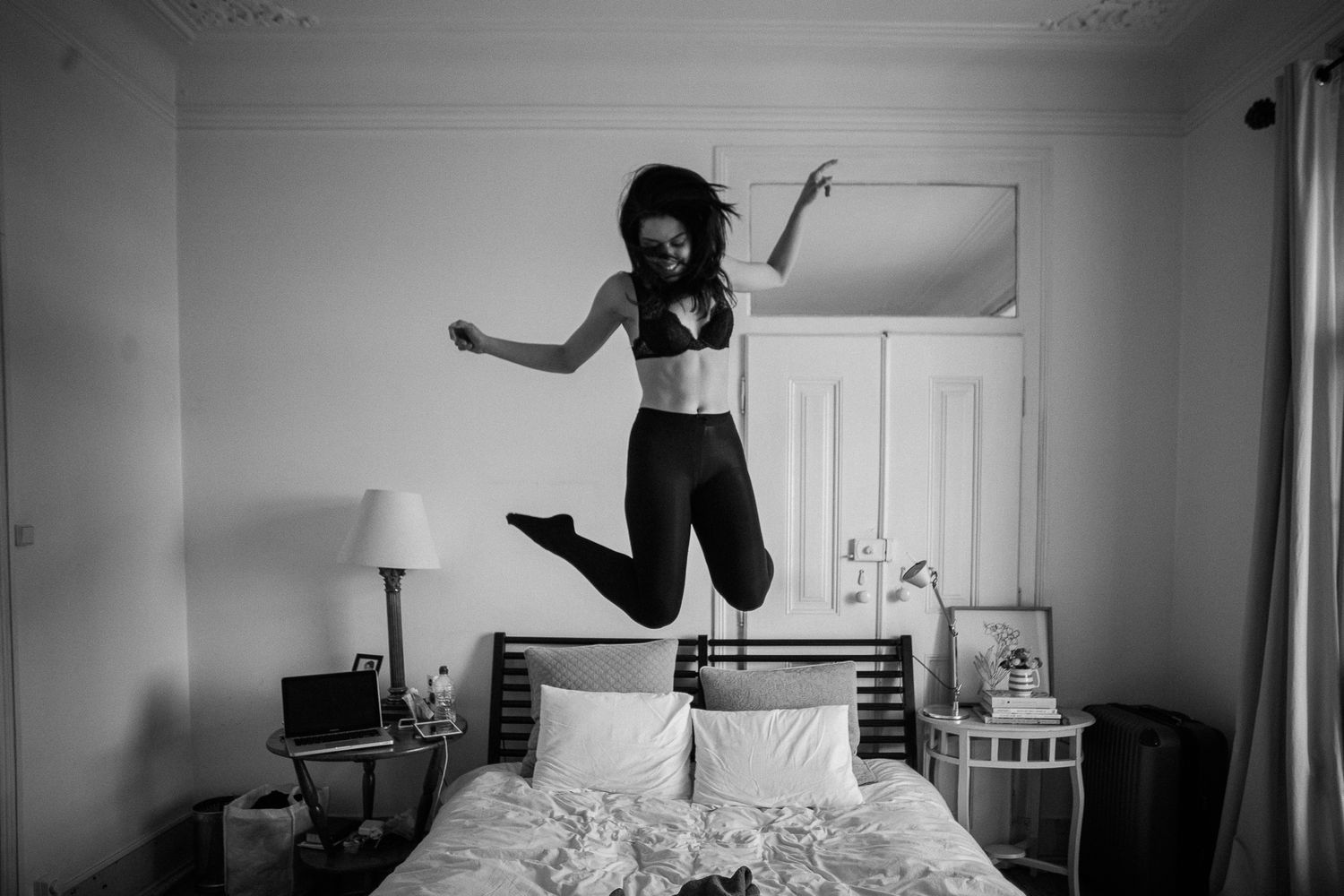 A black and white photo sequence shows someone jumping on a bed in four progressive frames.