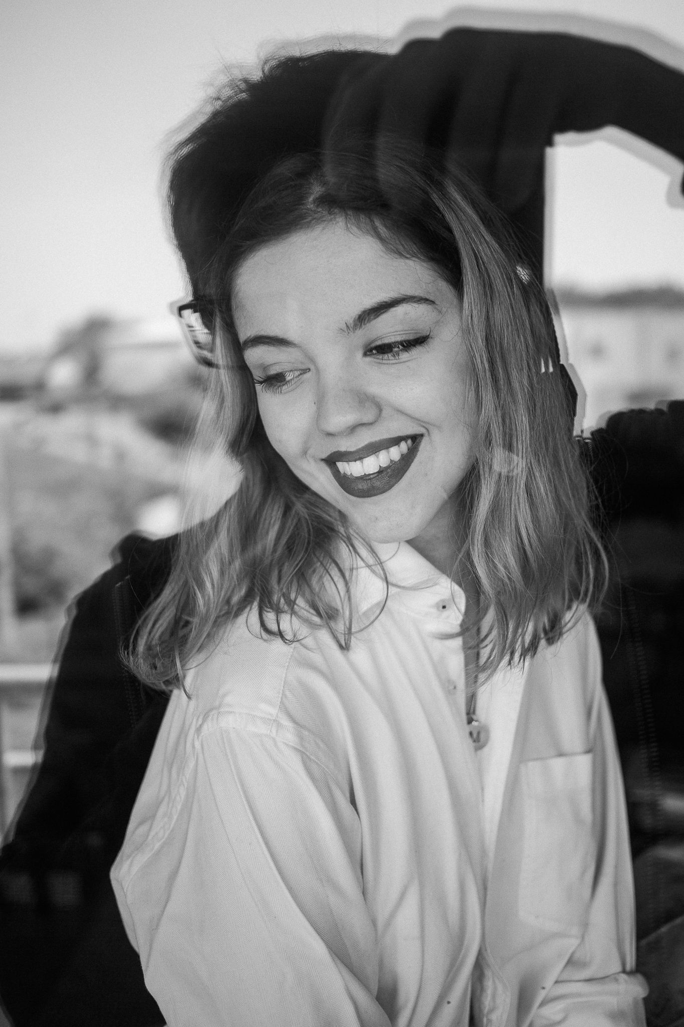 Black and white photo series showing candid expressions and joyful laughter while wearing a white top.