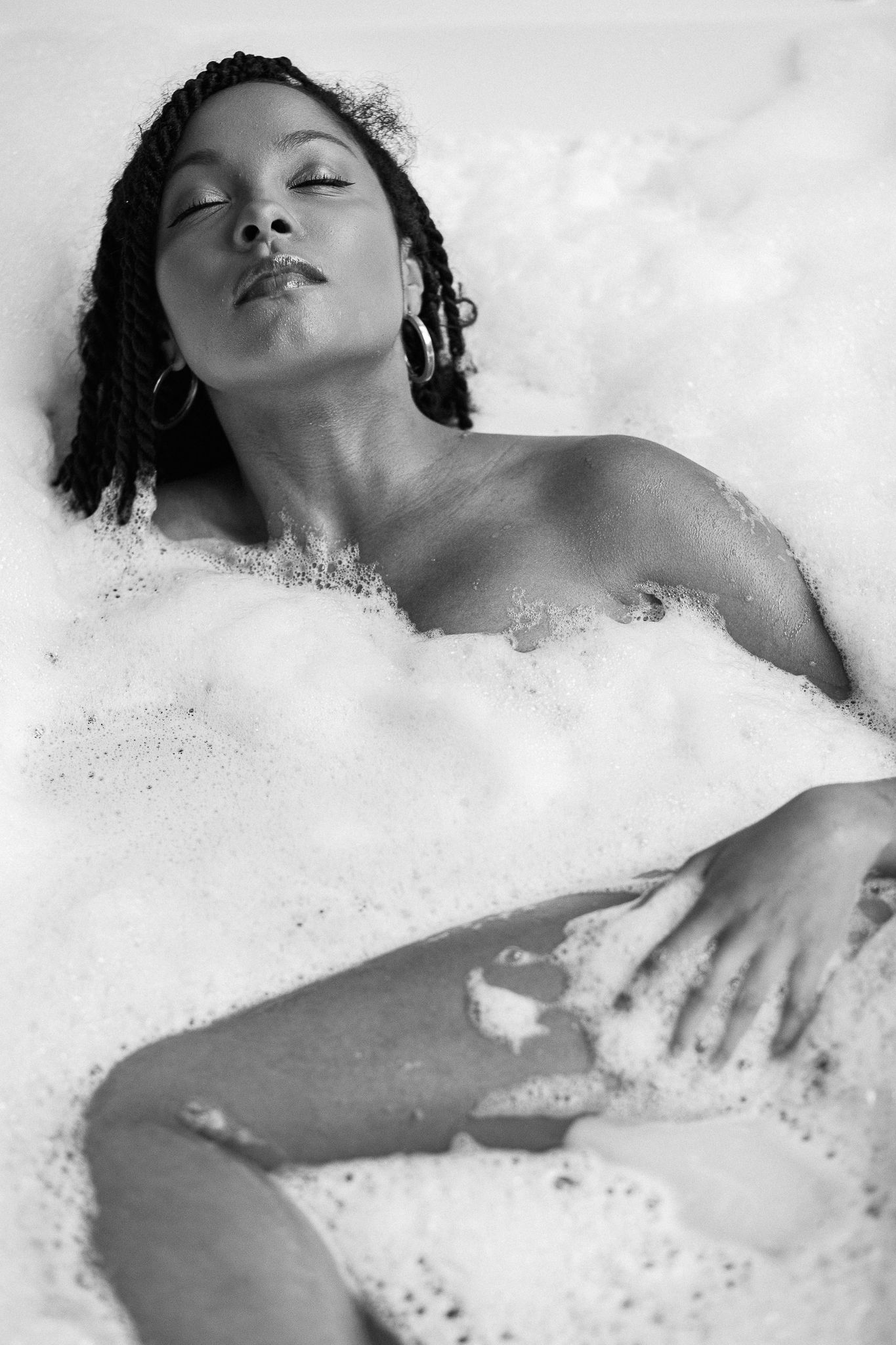 Sensual black and white photographs capturing peaceful moments in a bubble bath.