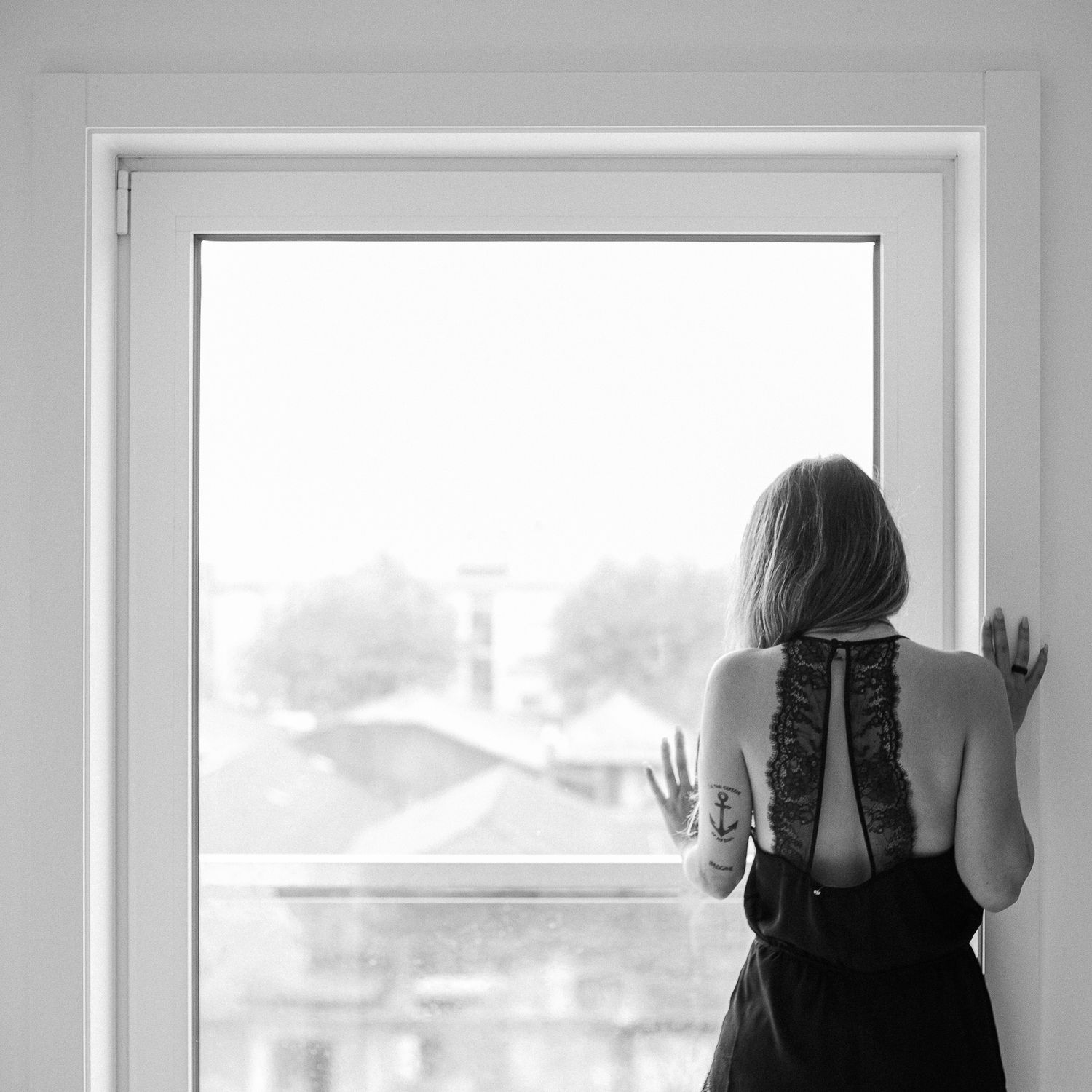 Black and white artistic portrait series showing a person in dark clothing near a window.