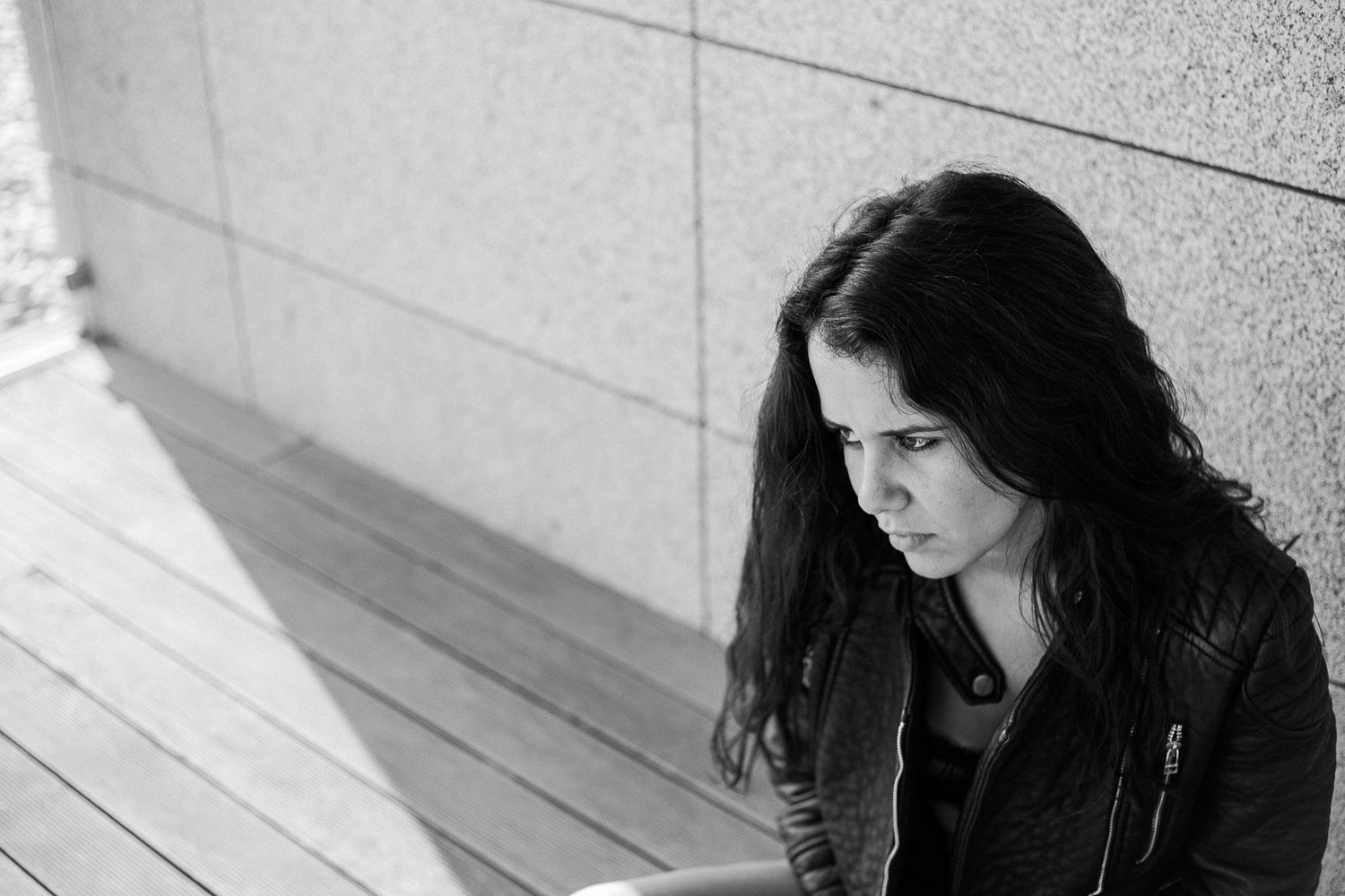Black and white portrait series showing dark hair and dramatic lighting against a light background.