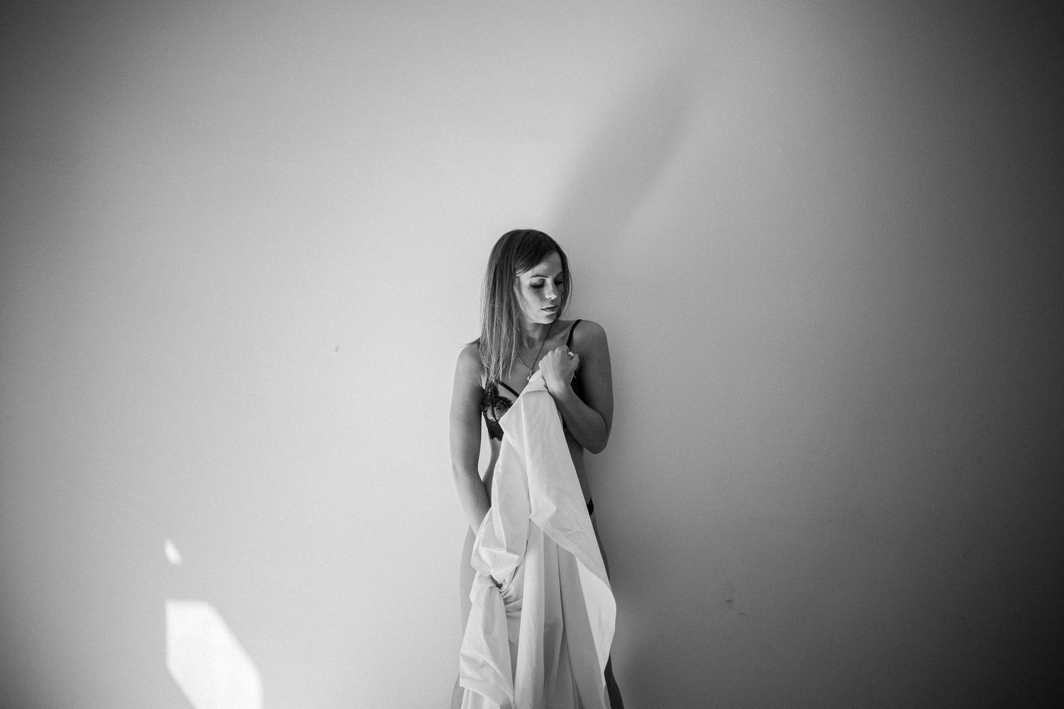 Black and white artistic photo series showing a figure in white dress against dark background in various poses.