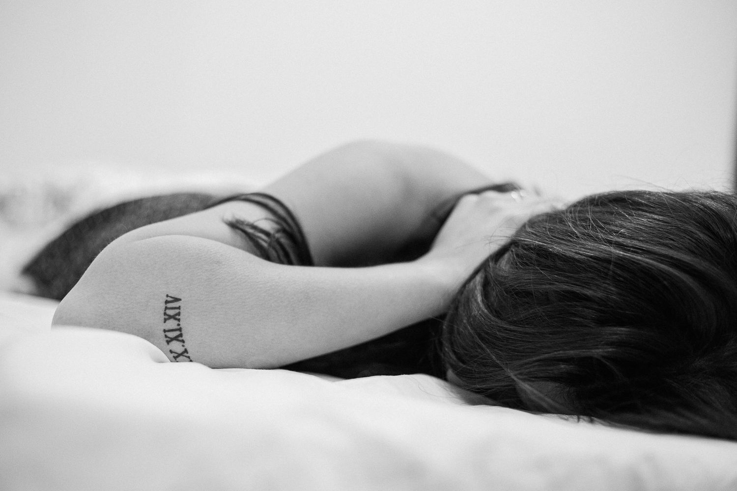 A black and white artistic photo series showing the curves and shadows of a reclining figure against a light background.