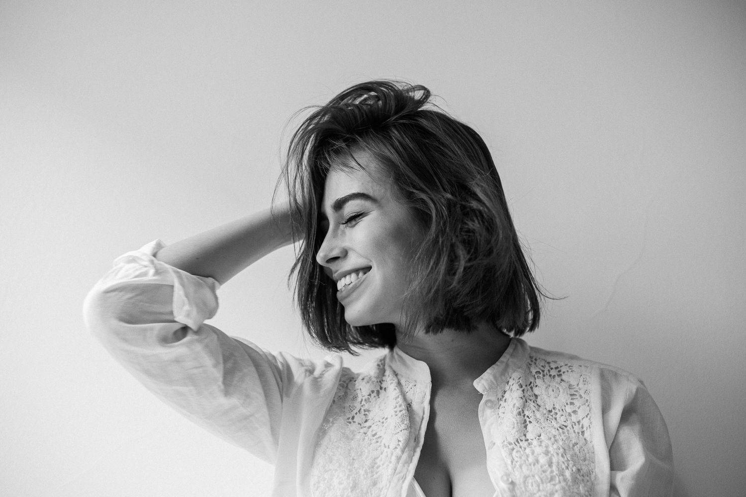 A black and white photo series showing a figure in white lace posing dramatically against a light background.