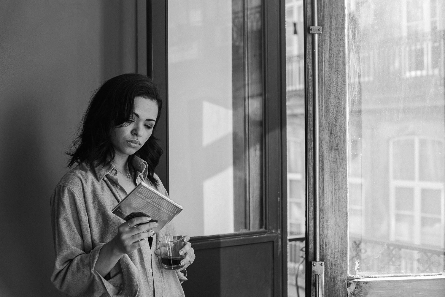 Black and white indoor portraits with strong window lighting and urban views.