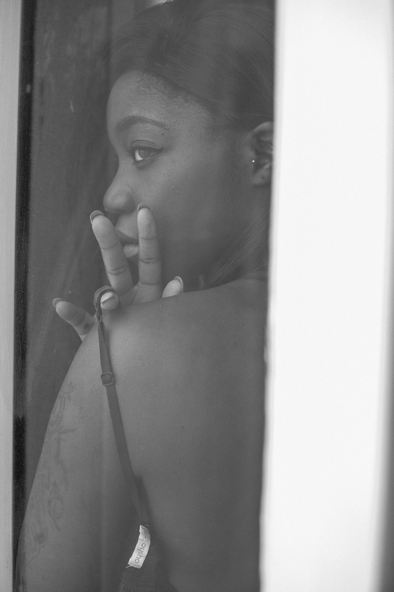 Black and white photo series showing multiple reflective portraits through glass or mirrors in an artistic composition.