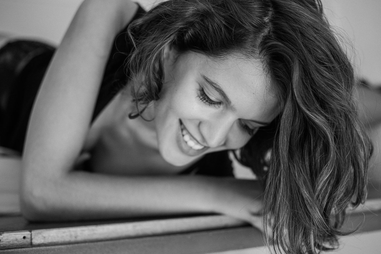 Black and white artistic portrait series showing a person lying down in contemplative poses.
