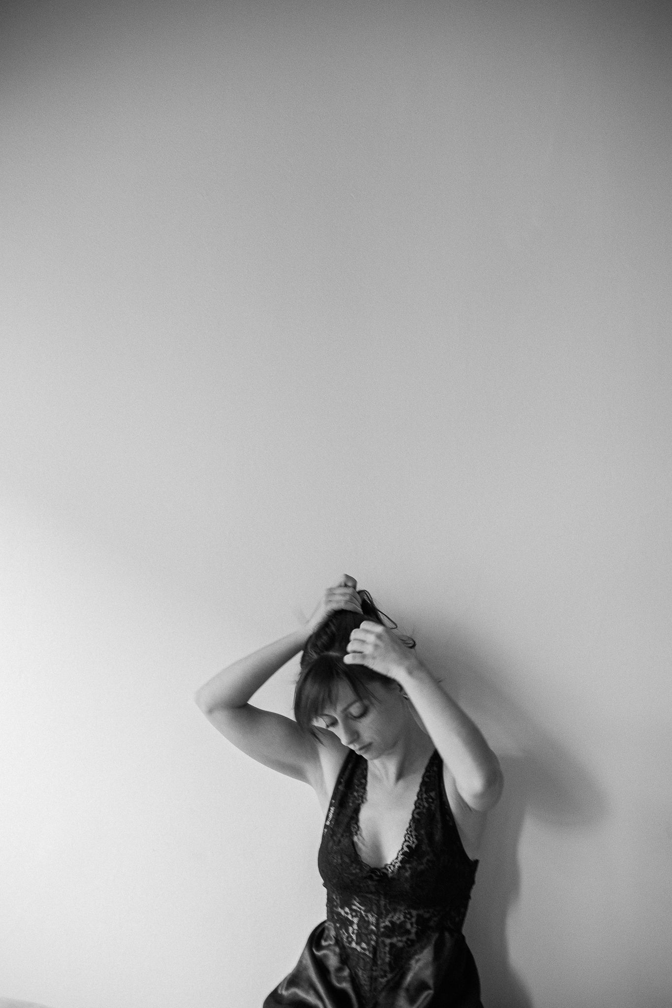 Minimalist black and white photos against plain wall showing emotional poses.
