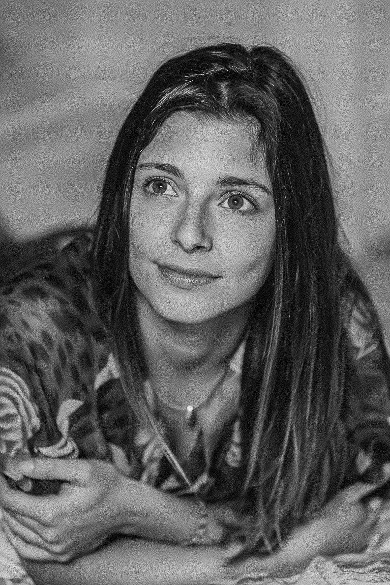 A black and white photo sequence shows a person with dark hair lying down and making playful expressions.