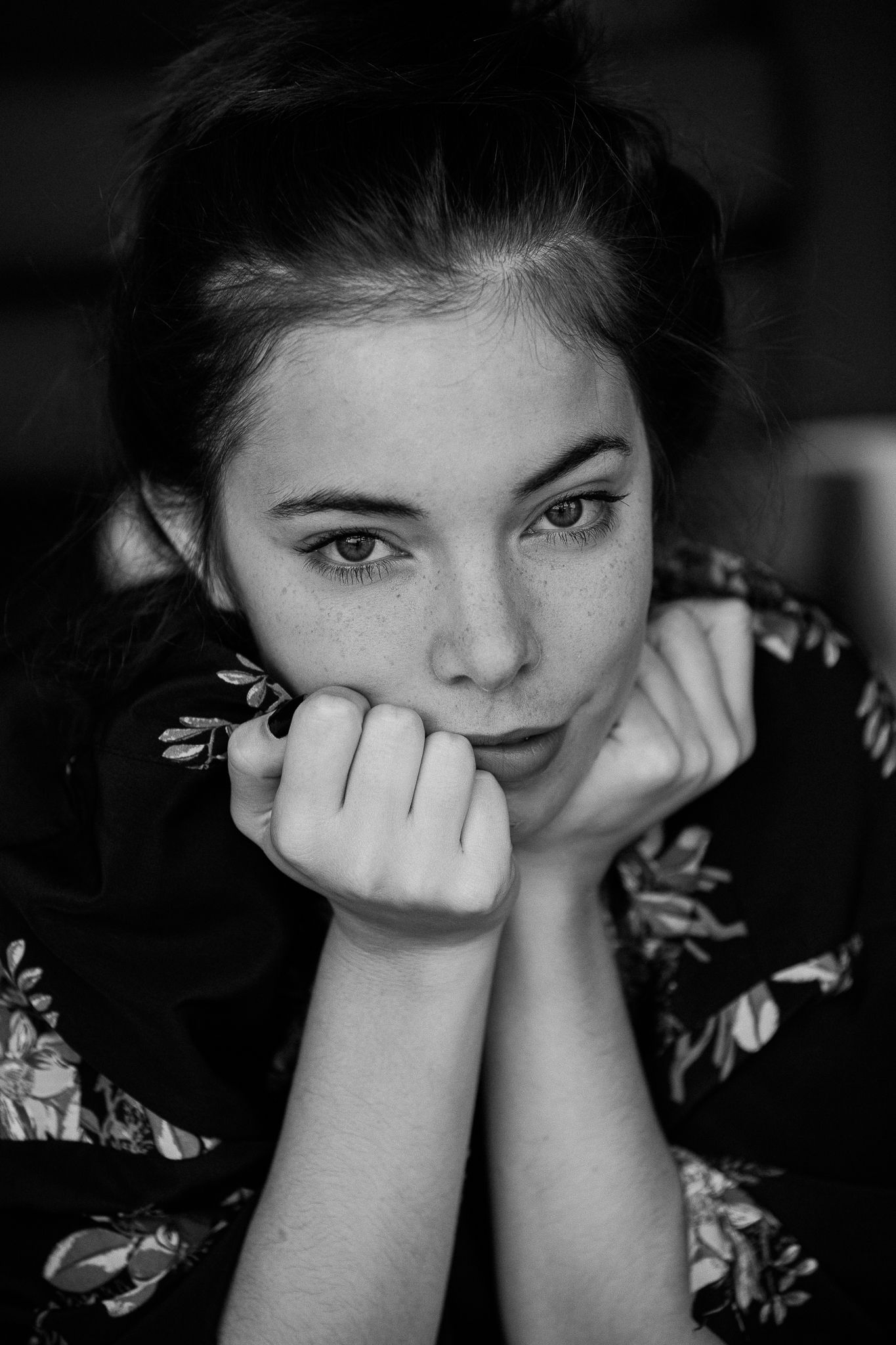 Intimate black and white portrait with floral pattern clothing and expressive eyes.