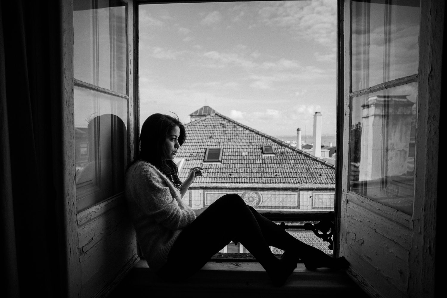 A series of black and white architectural photos showing windows, doorways and building silhouettes against a bright sky.