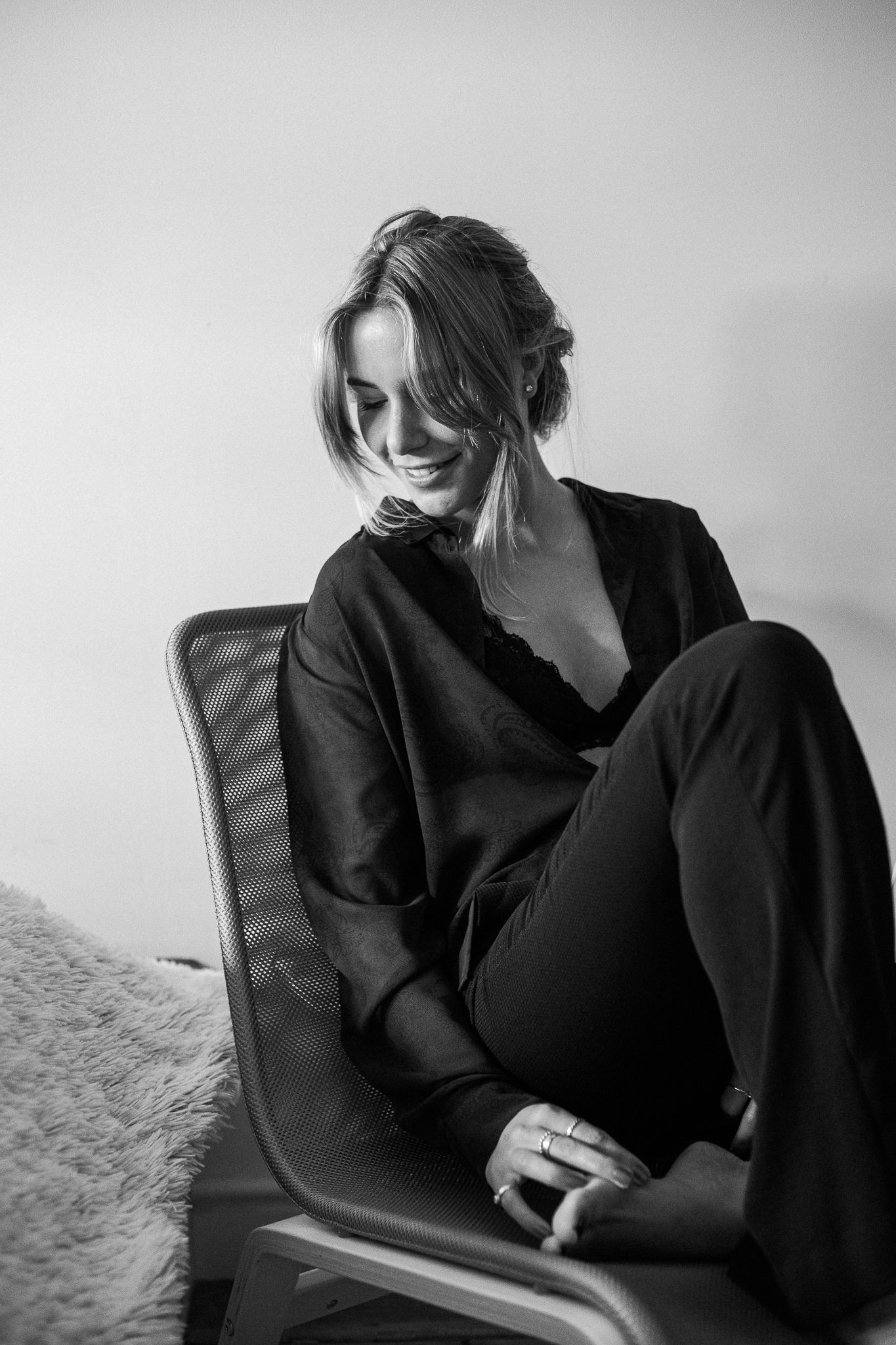 A black and white photo series showing a person in dark clothing sitting on a chair in various contemplative poses.