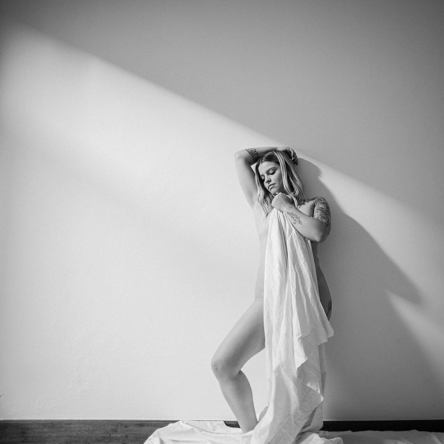 A minimalist black and white photo series showing flowing white fabric against dark backgrounds in abstract forms.