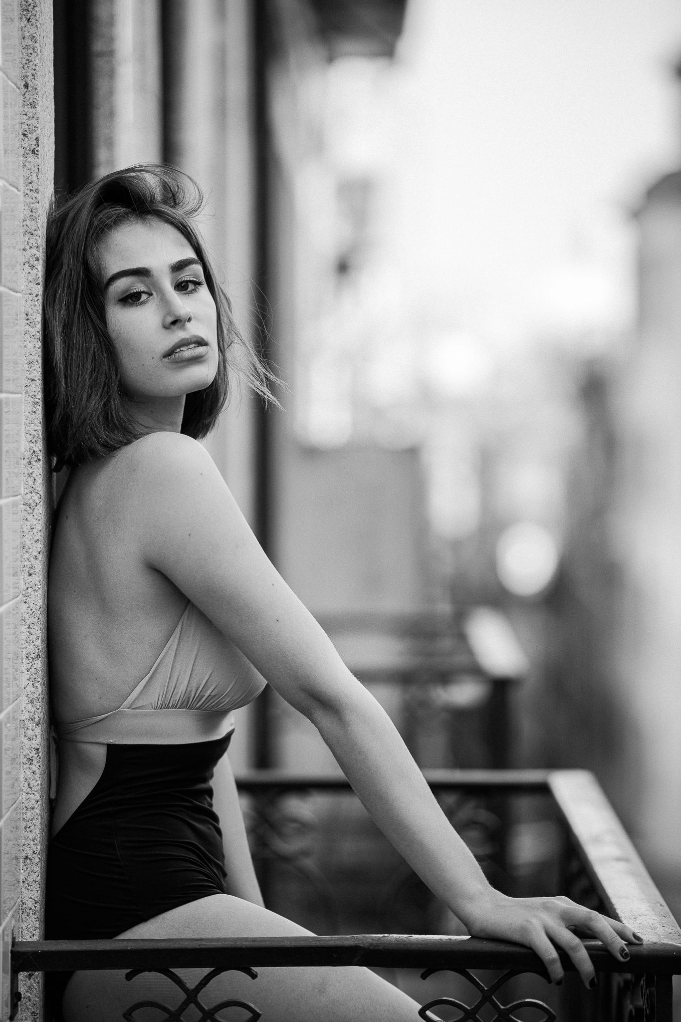 Black and white portrait series showing a person in a dark top posing against a light background.