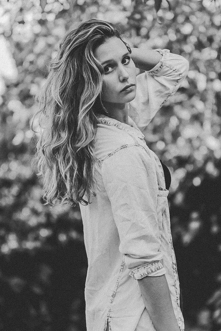 Black and white artistic portrait series showing a woman in a white dress posing against a bokeh background.