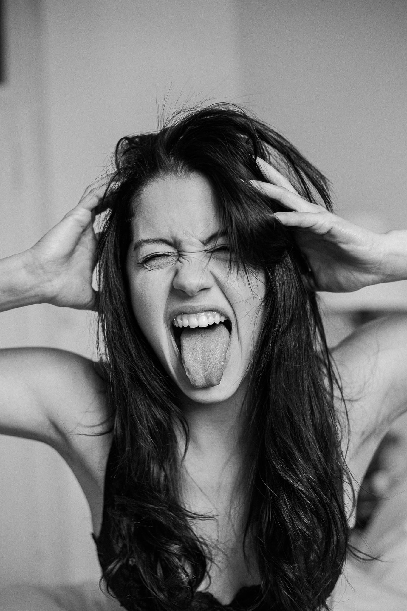 A black and white photo series showing expressive moments with dark hair and playful emotions.