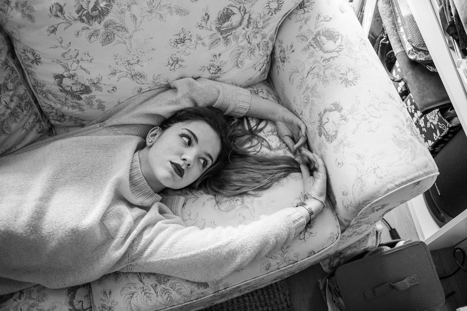 A collection of black and white photographs showing someone resting on floral patterned bedding in different poses.