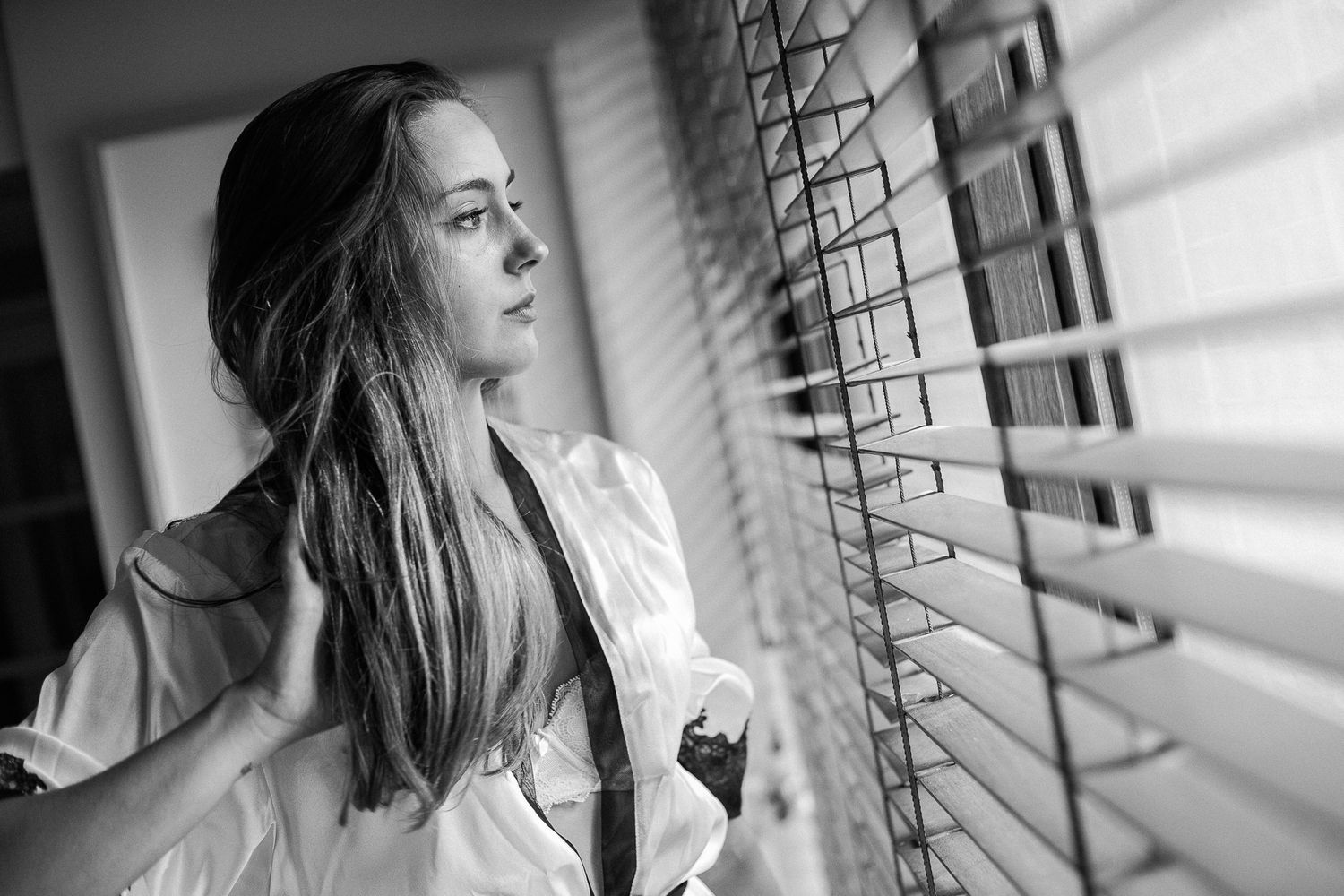 Black and white portrait series showing a woman near a window with dramatic lighting and shadows.