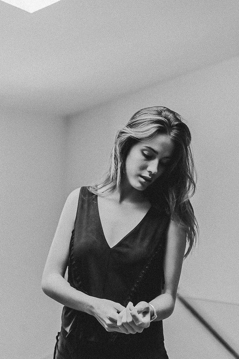 Black and white portrait series showing a person in a dark sleeveless top with dramatic lighting and poses.