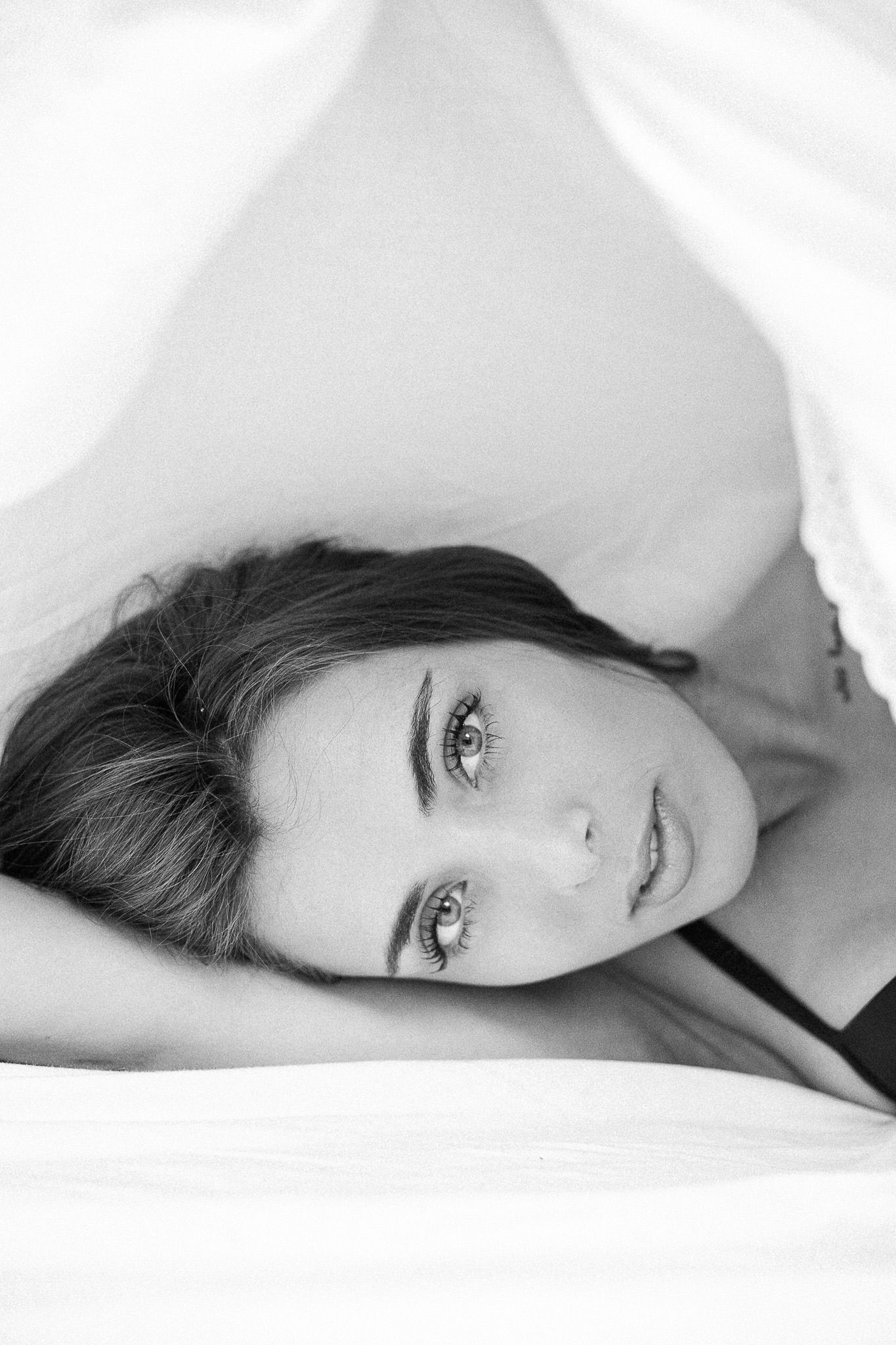 Intimate black and white boudoir portraits on white bedding.