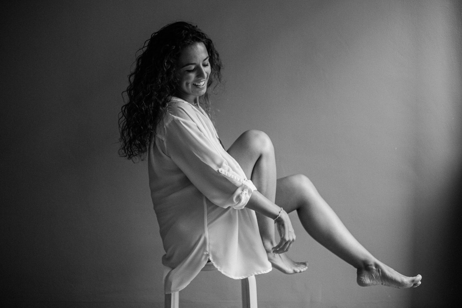 Black and white artistic boudoir photography series showing intimate poses in soft lighting and shadows.