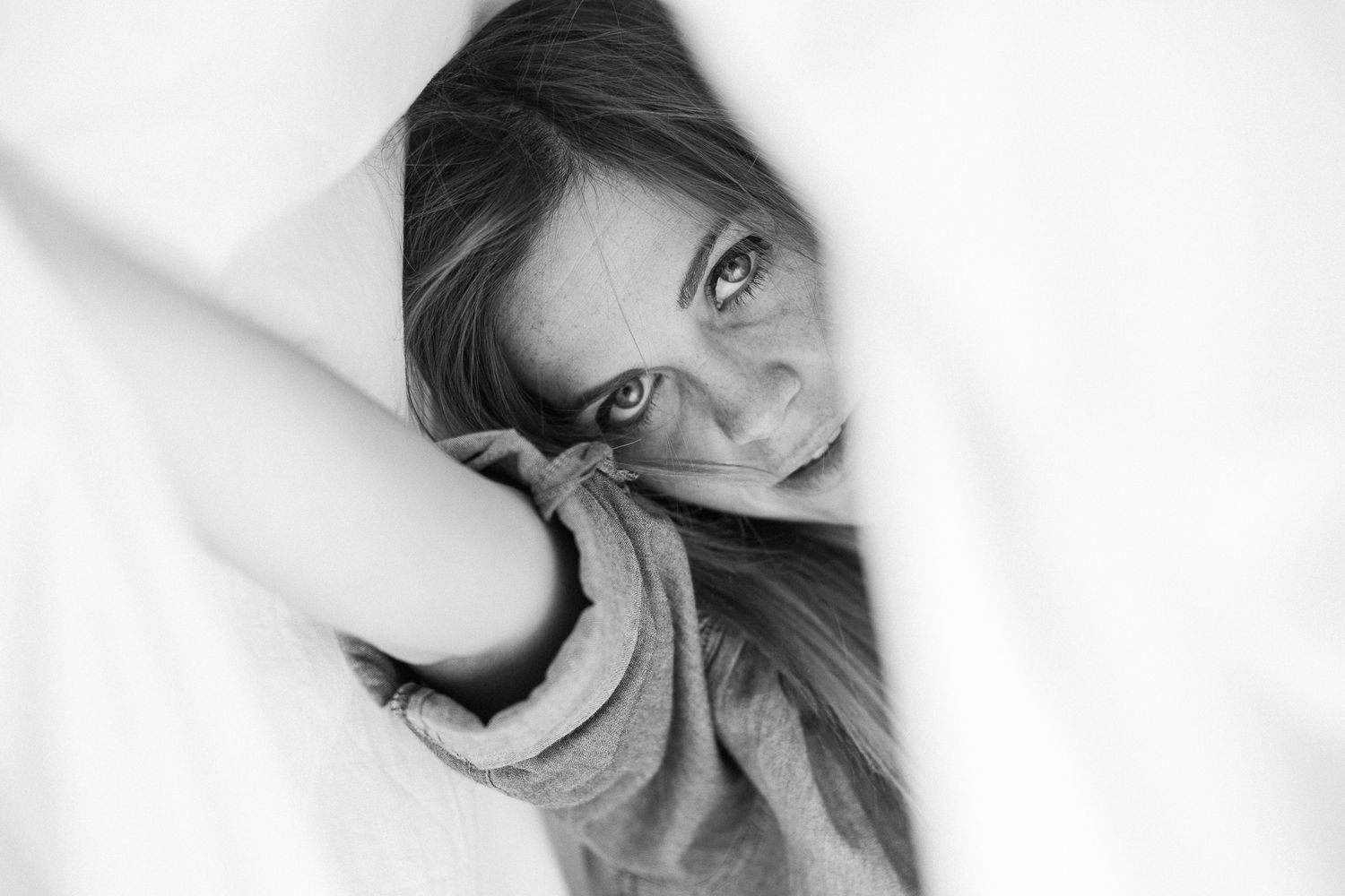 Black and white artistic portrait series showing moody close-up expressions against white background.
