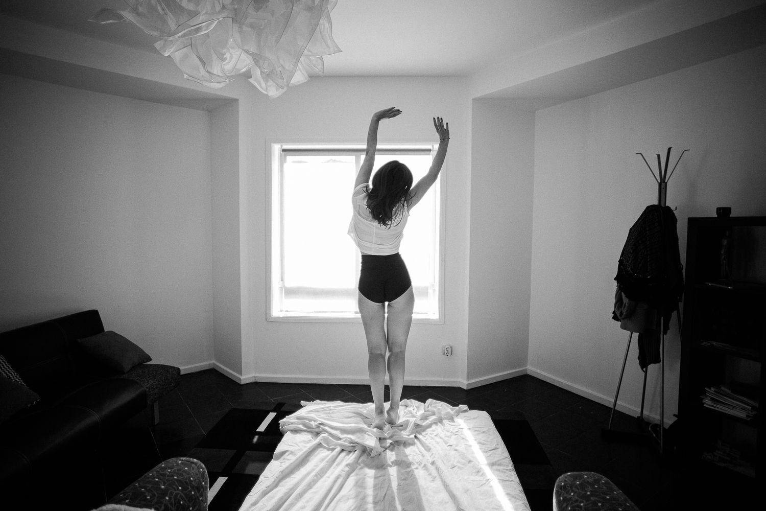 A black and white photo series showing a figure in silhouette moving gracefully through different dance poses in a room.