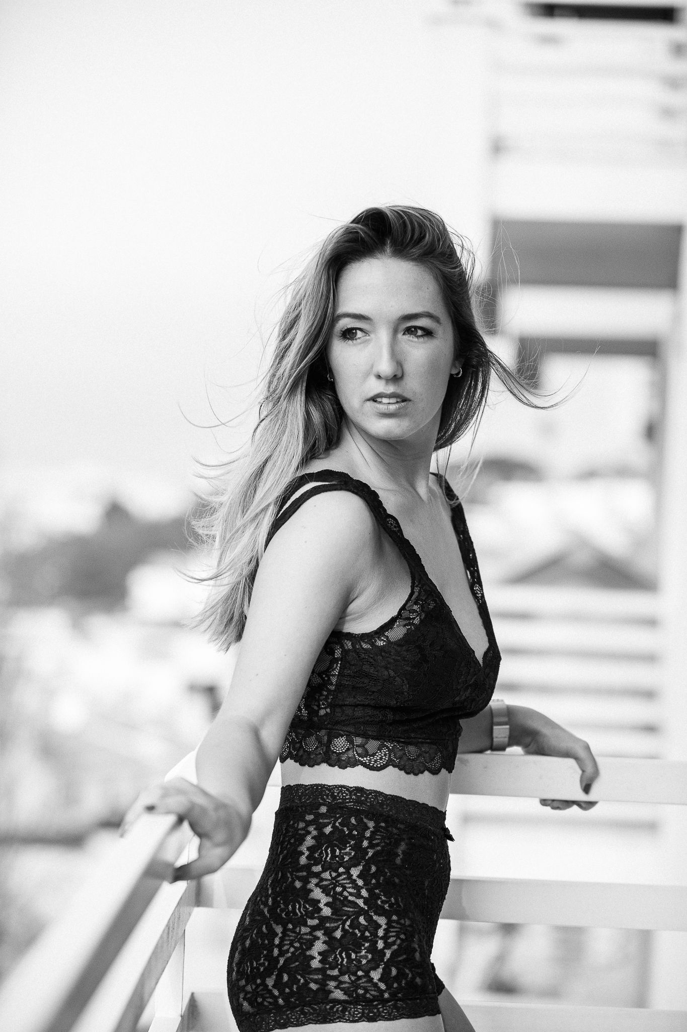 Fashion portrait series in black lace dress against bright background.