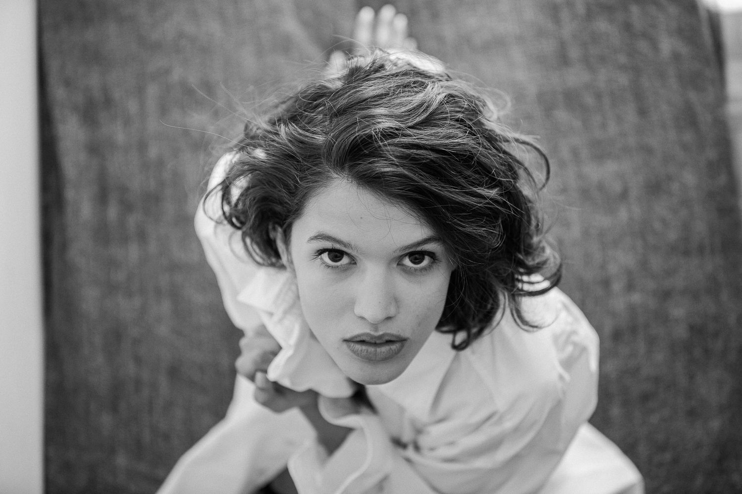 A black and white photo sequence shows a person in white looking playfully at the camera from different angles.