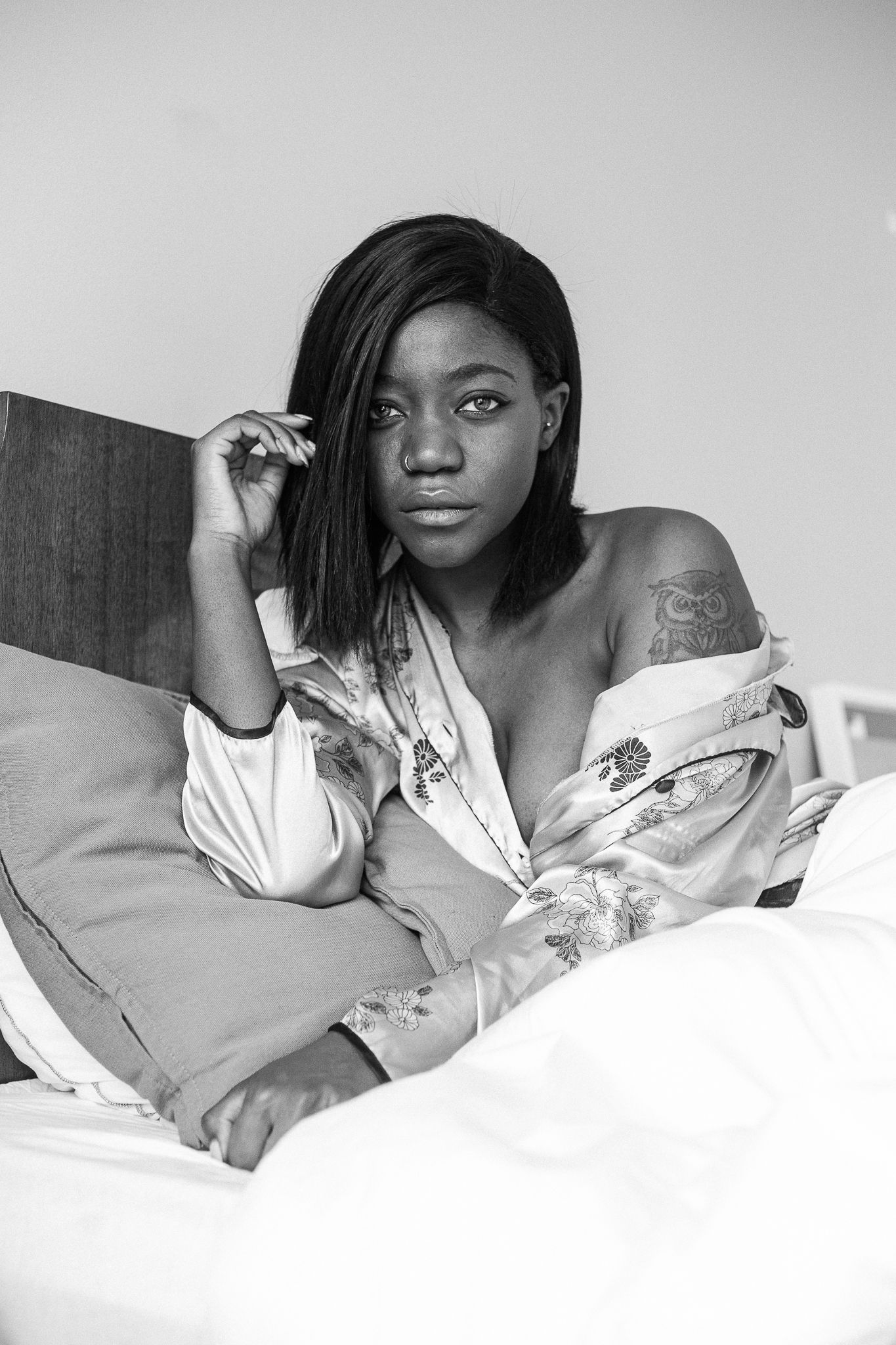 A series of black and white photographs showing someone relaxing in bed wearing a light-colored top.