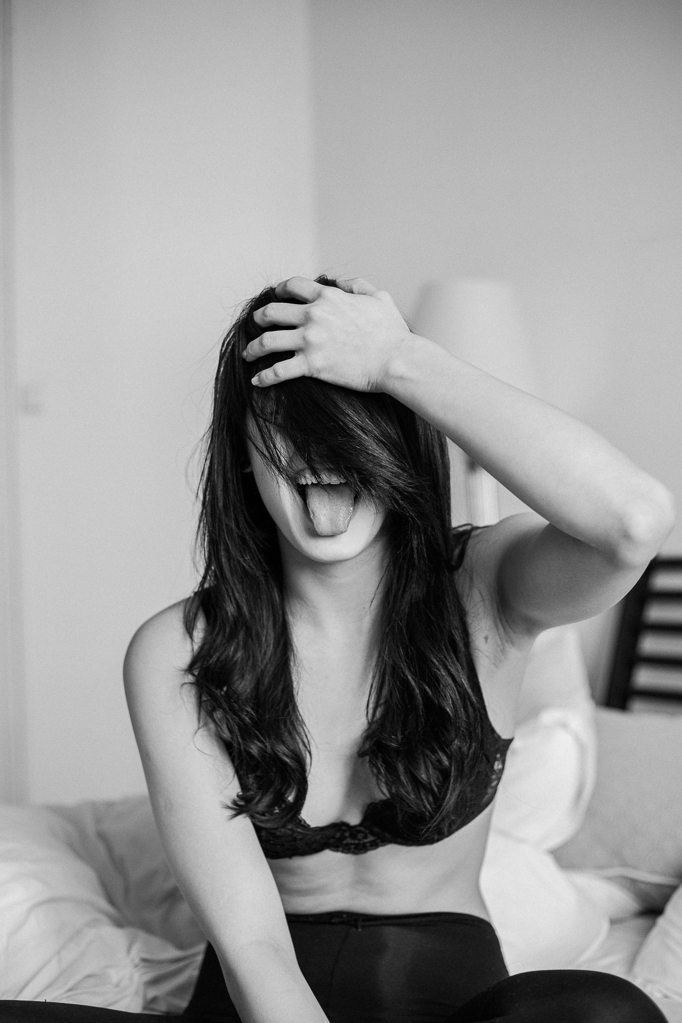 A series of black and white photos showing someone with dark hair laying on white bedding in various poses.