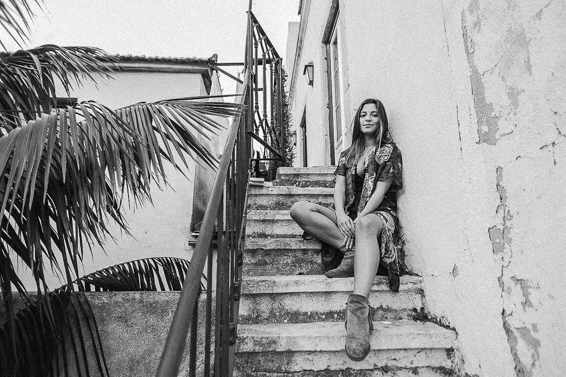 A black and white photo series shows someone posing on outdoor steps in various artistic poses.