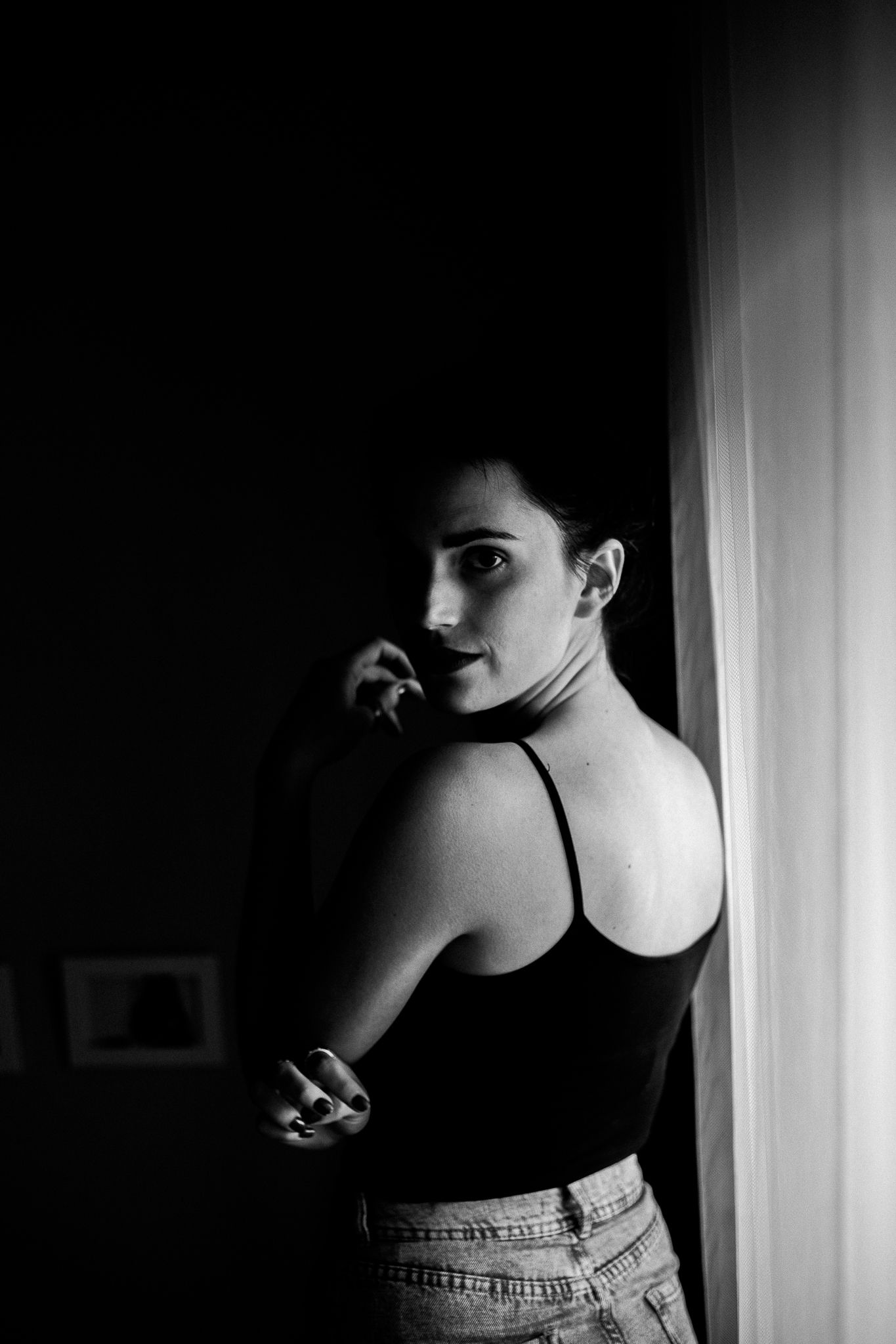 A series of black and white photographs showing a woman's silhouette in moody lighting against a window.