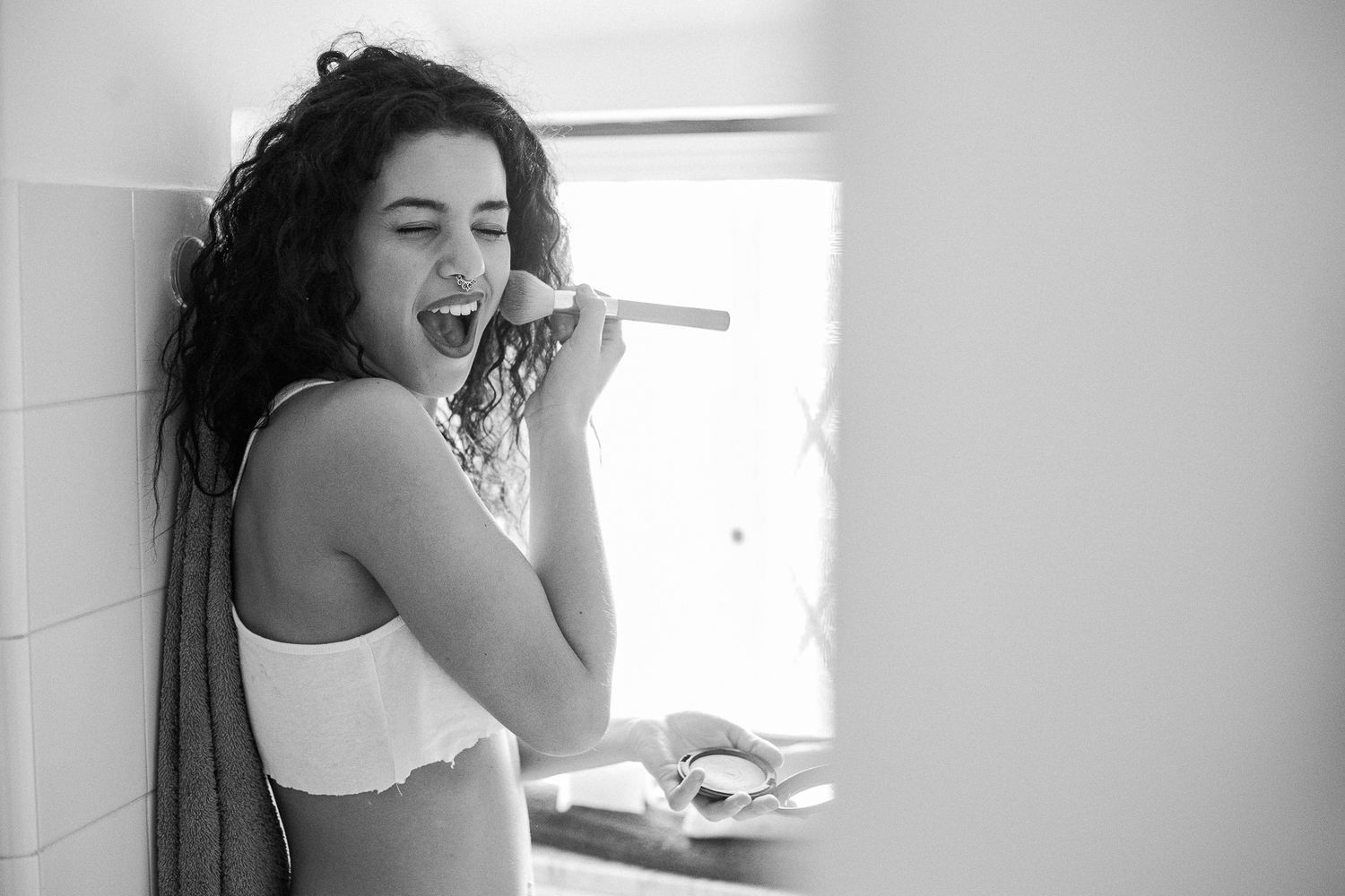 Black and white photo sequence showing a person brushing teeth and getting ready in a bathroom mirror.