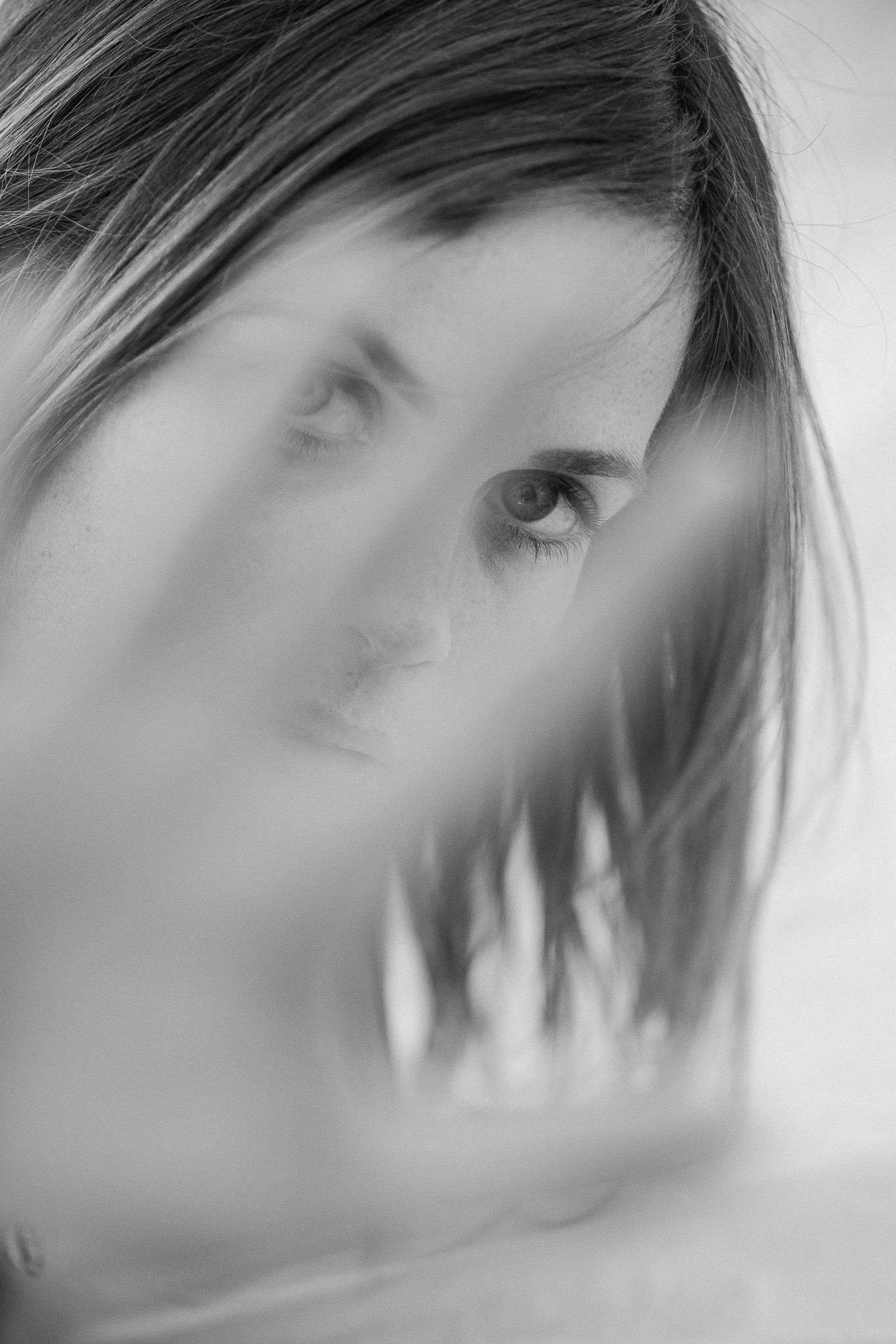 A series of progressively blurred black and white portraits showing motion and fading effects.