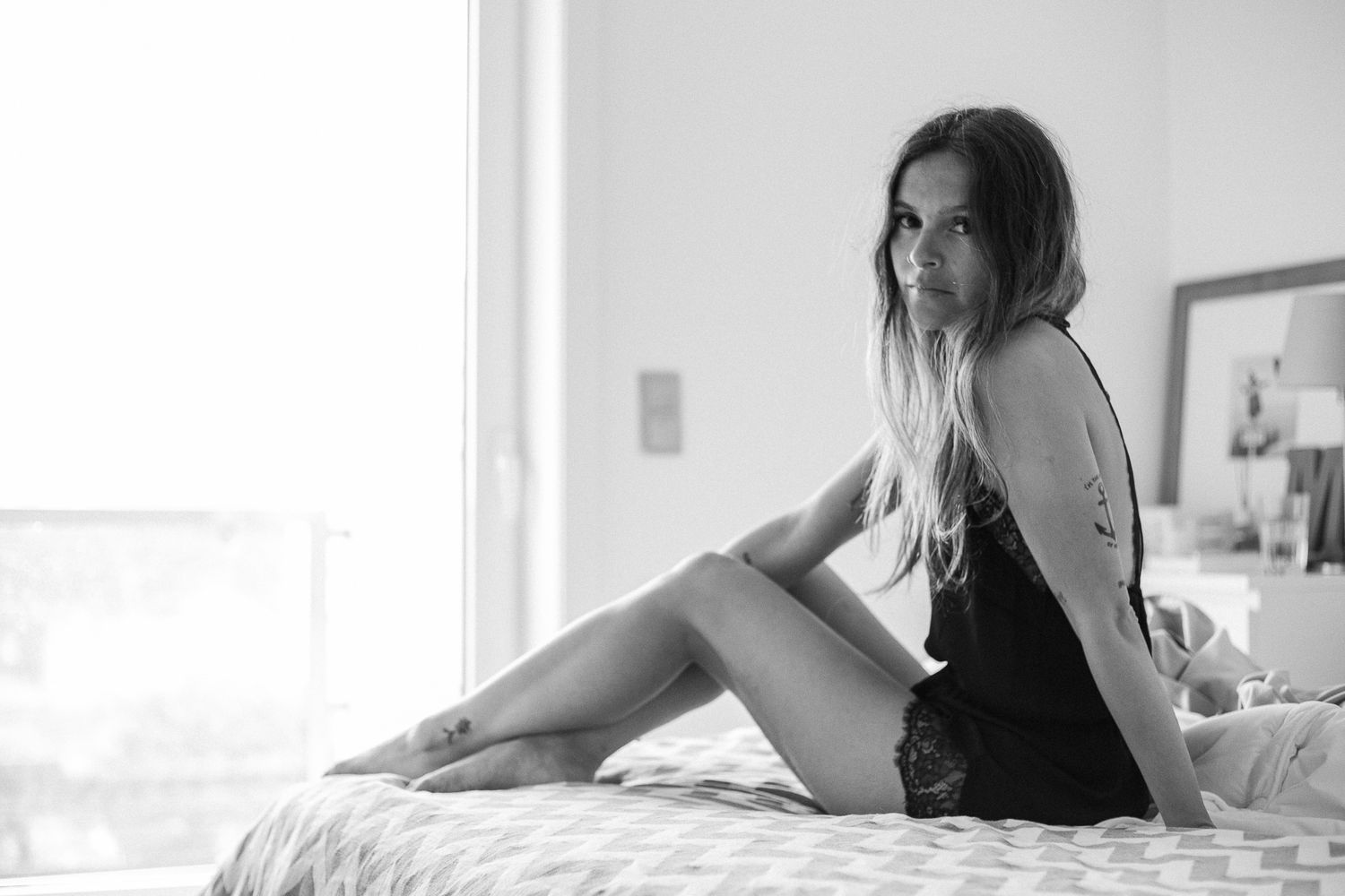 Minimalist black and white bedroom photo with natural window light.