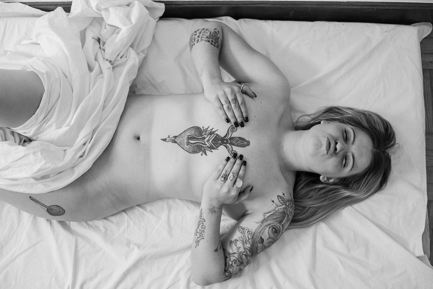 Black and white photo series showing intimate moments of someone resting in white bedding and sheets.