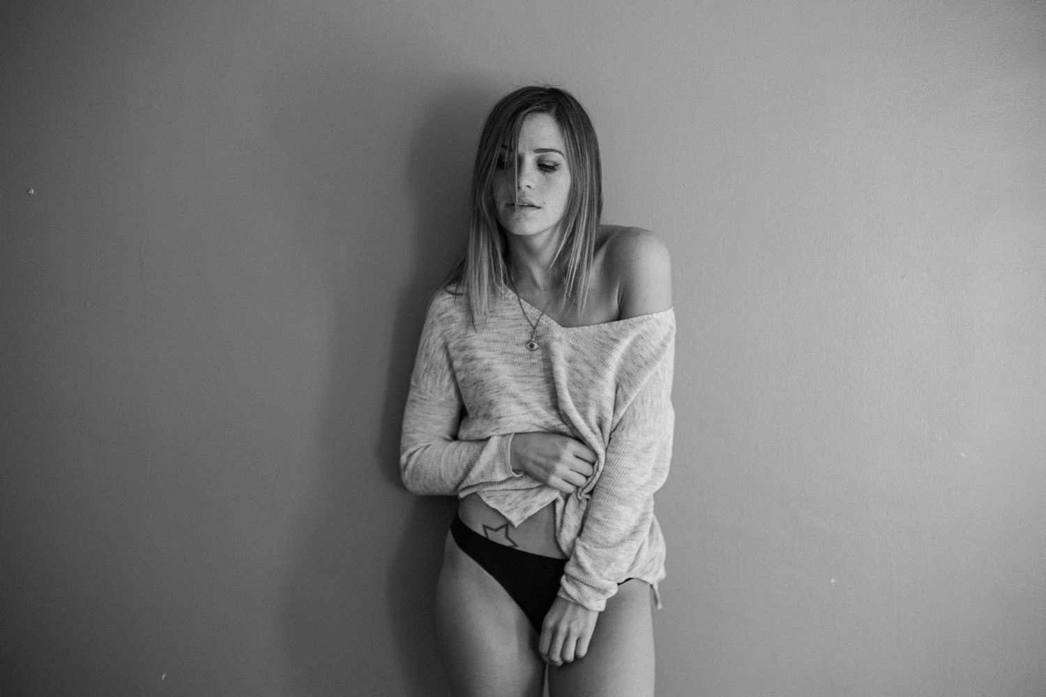 A black and white photo series showing a person in contemplative poses against a plain background.