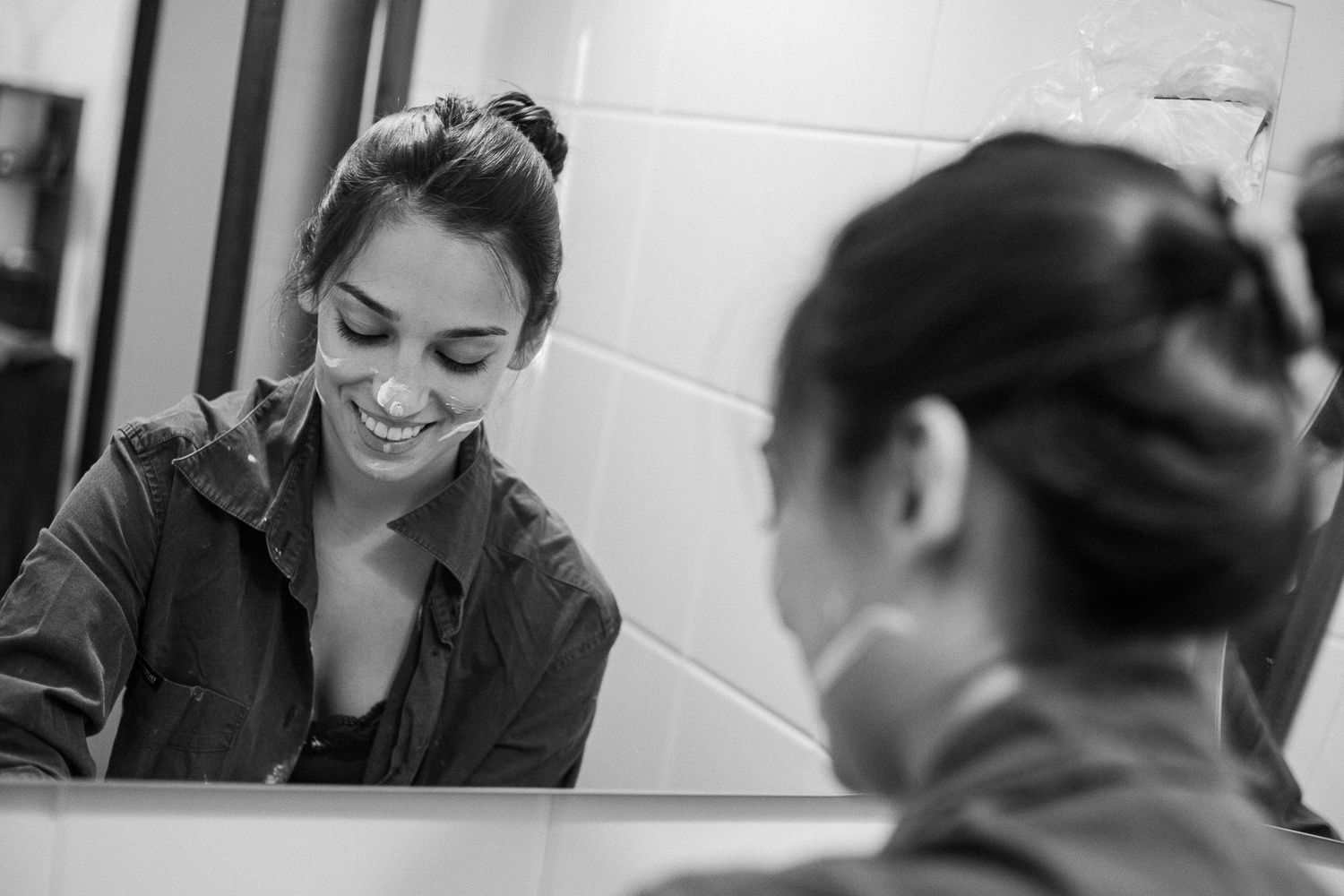 A series of black and white photos showing people engaged in conversation and smiling in an office setting.