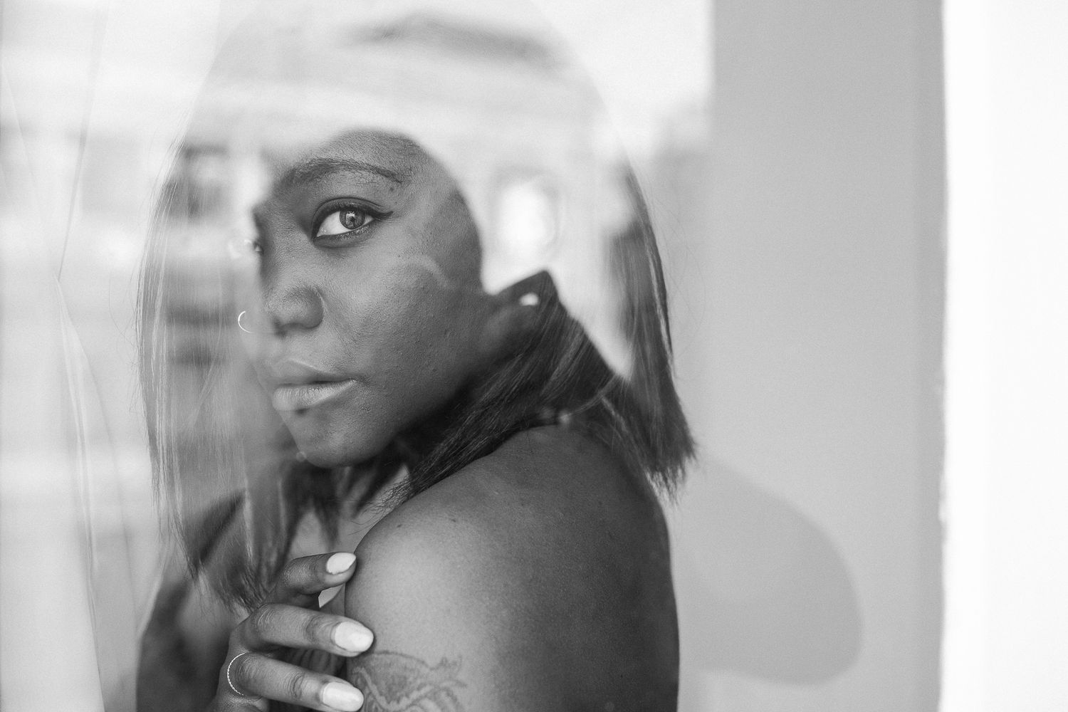 Black and white artistic photo series showing multiple overlapping reflective portraits with dramatic lighting effects.