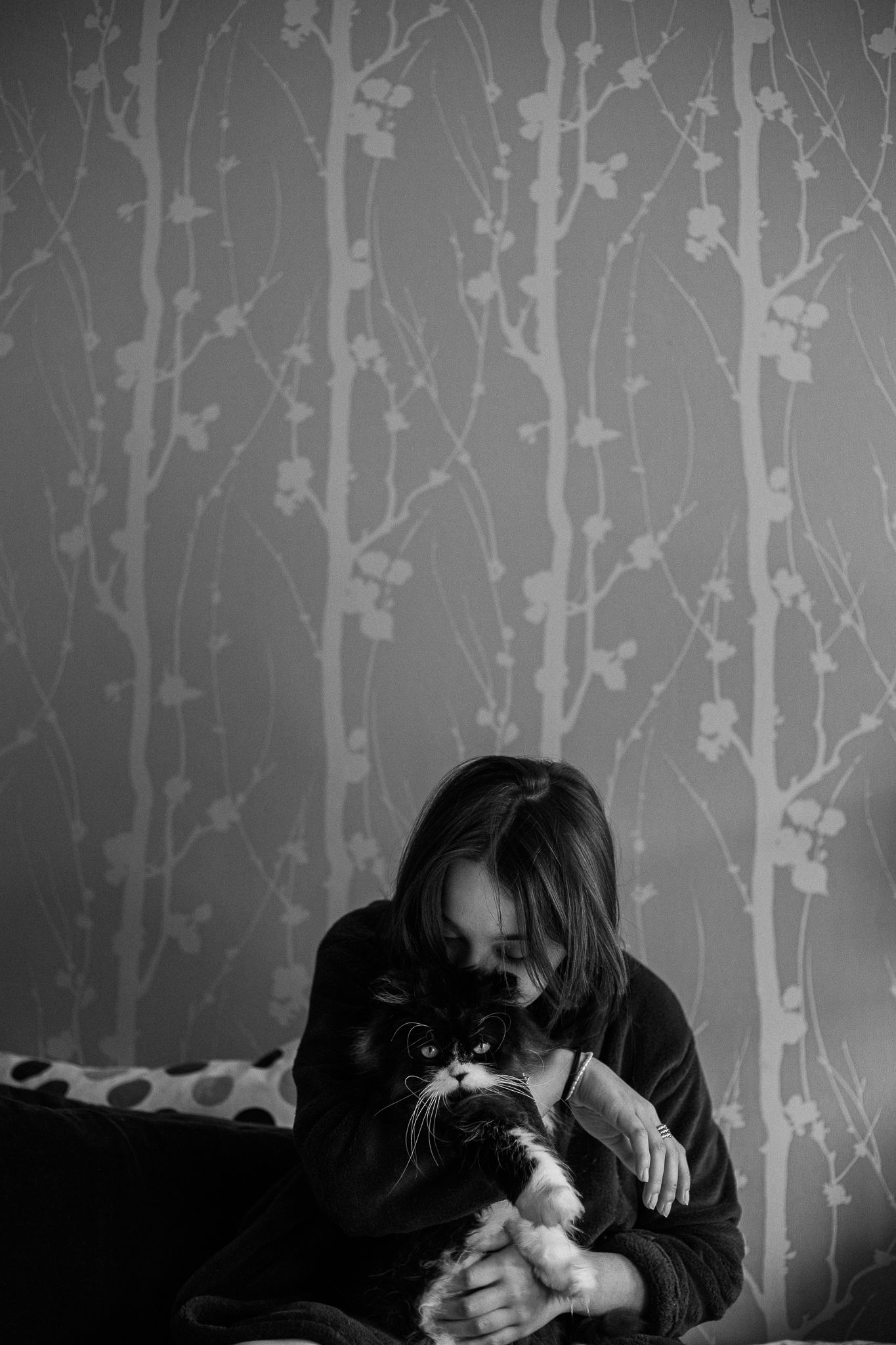 Monochrome series against birch tree patterned wallpaper in bedroom setting.