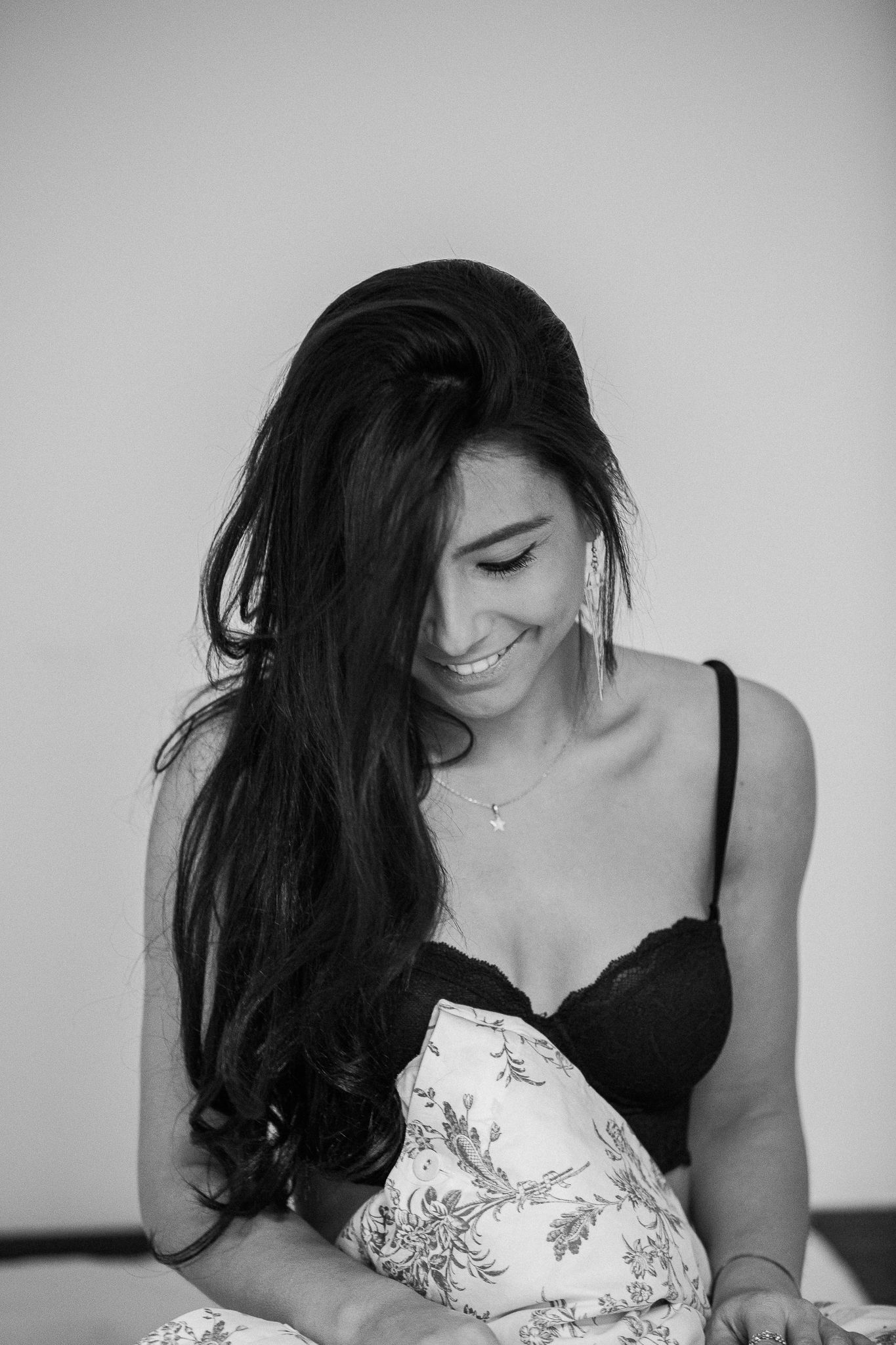 A series of black and white artistic portrait photographs showing someone in a black top and dark hair looking down.