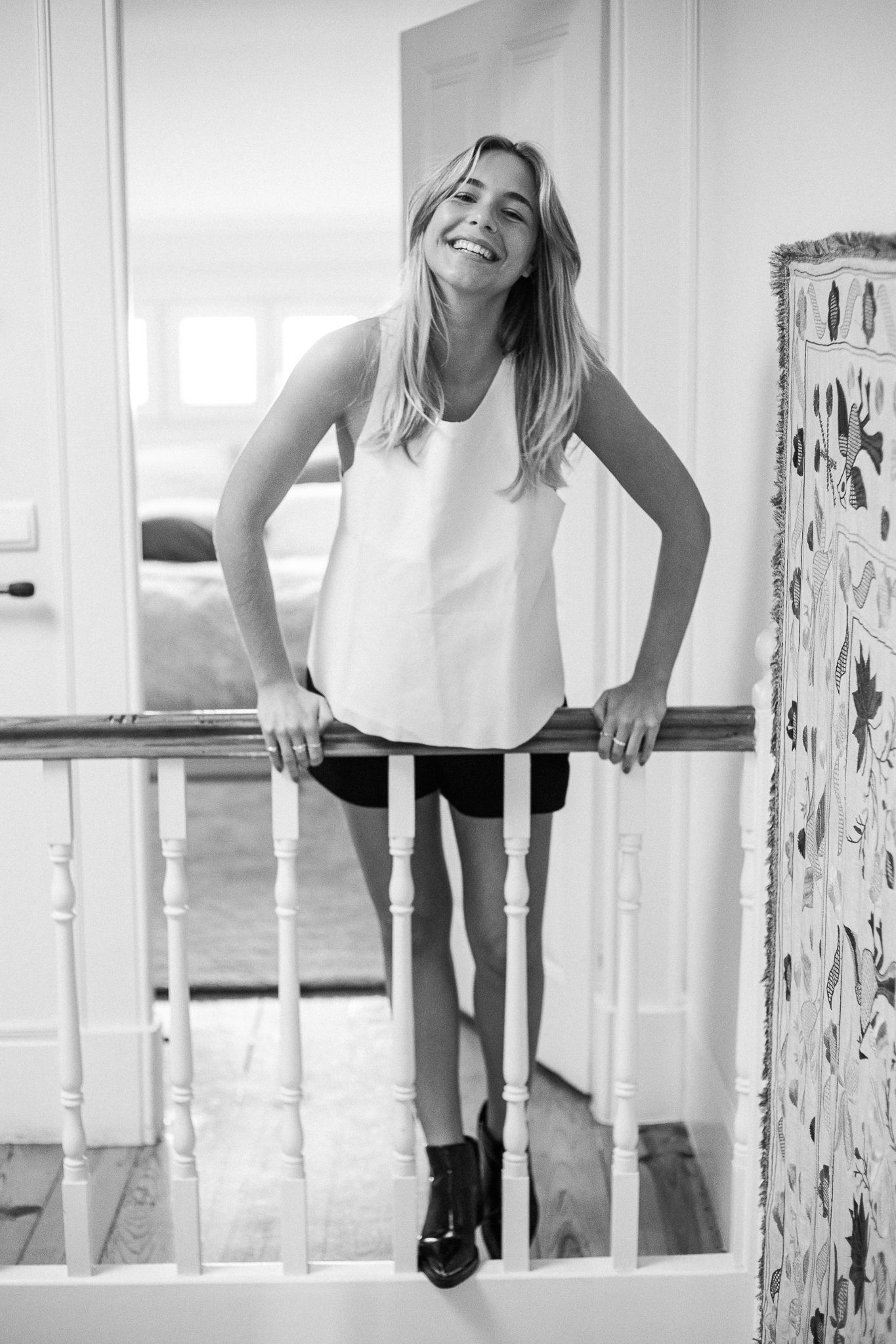 A black and white artistic photo series showing a person in a white top leaning over a balcony or railing.